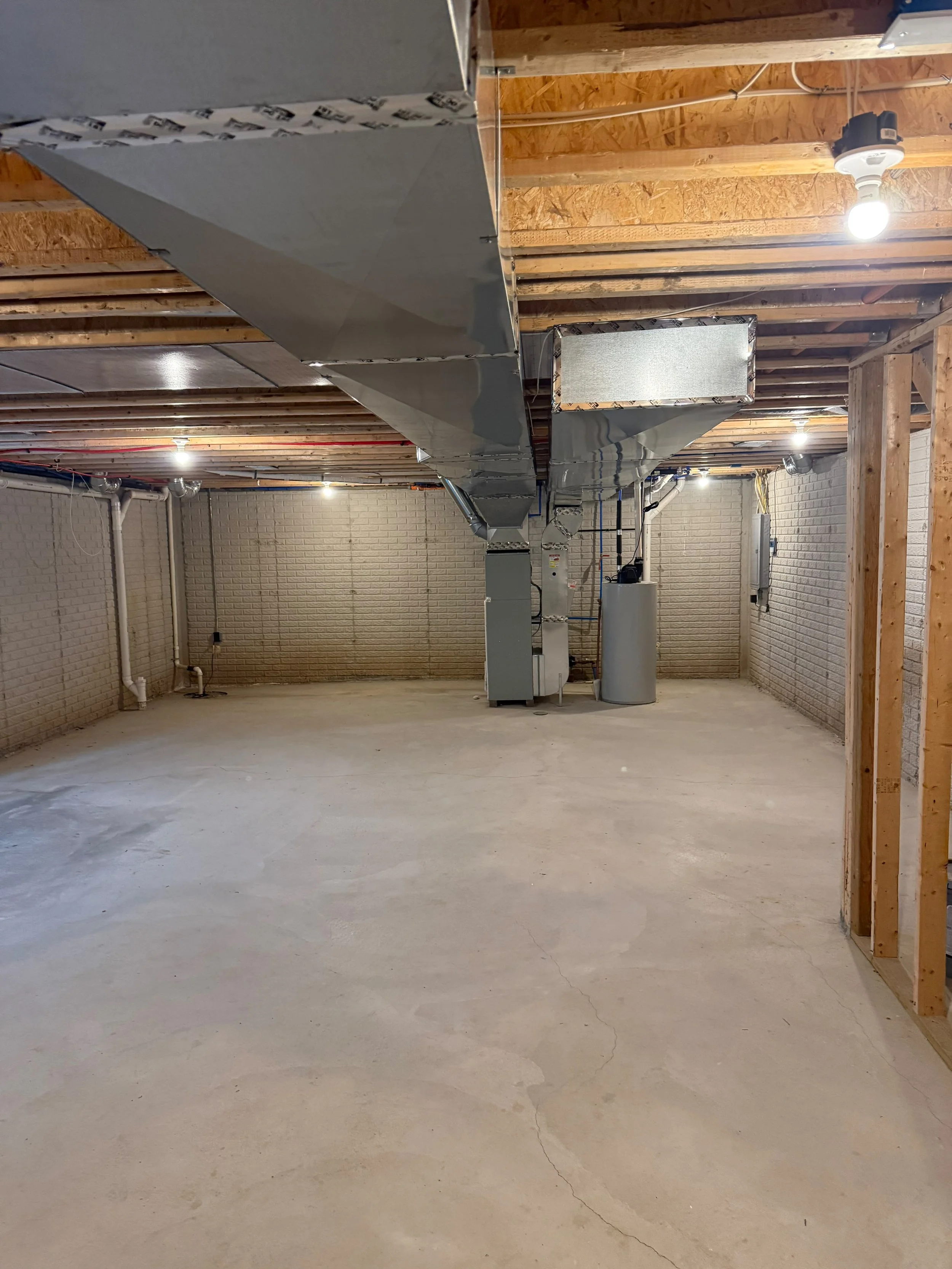 An unfinished basement with an open layout, providing the perfect foundation for a complete custom renovation.
