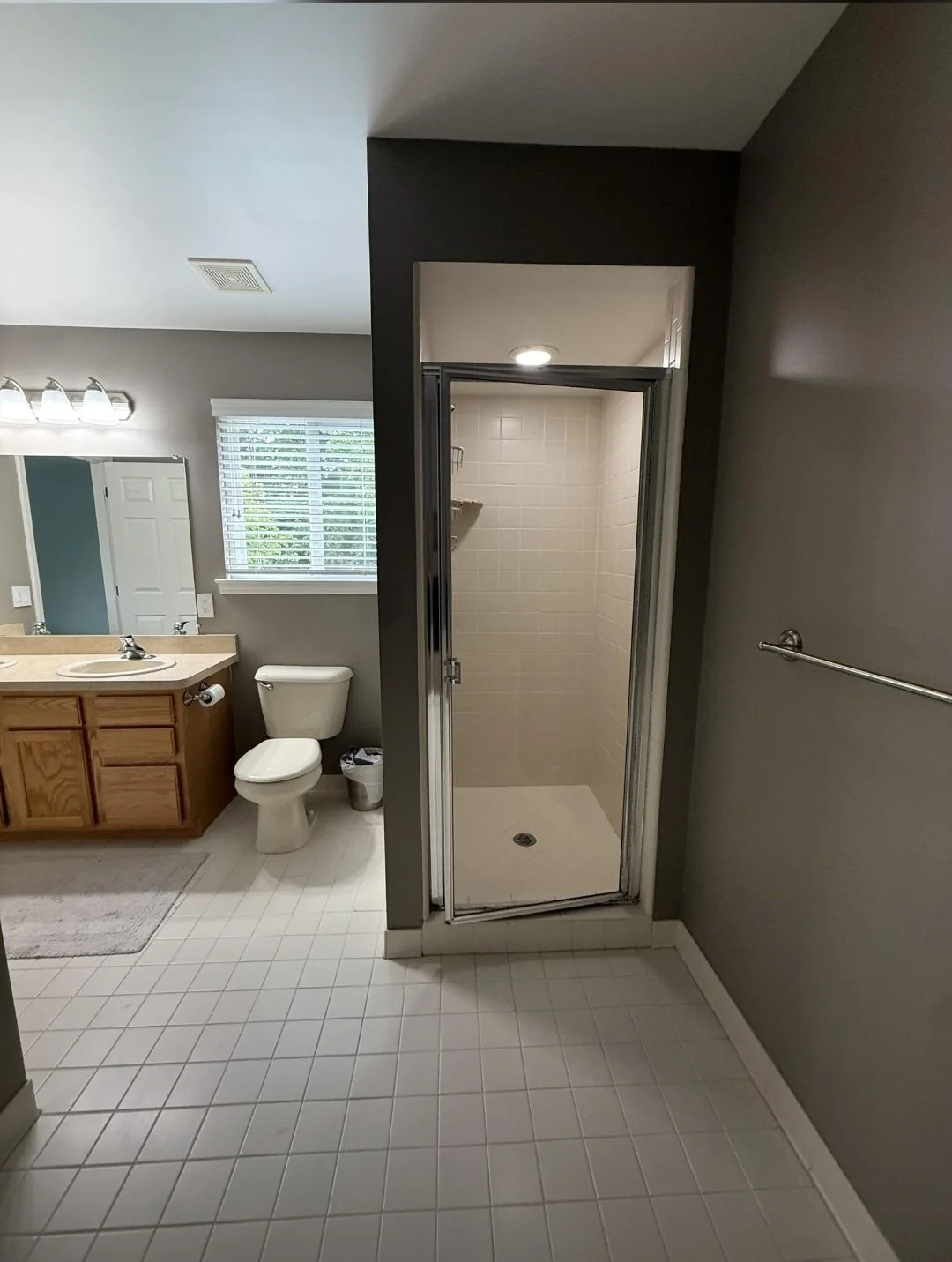 A full view of the completed bathroom showcases the seamless flow between the vanity, shower, and bathing areas, highlighting expert craftsmanship.