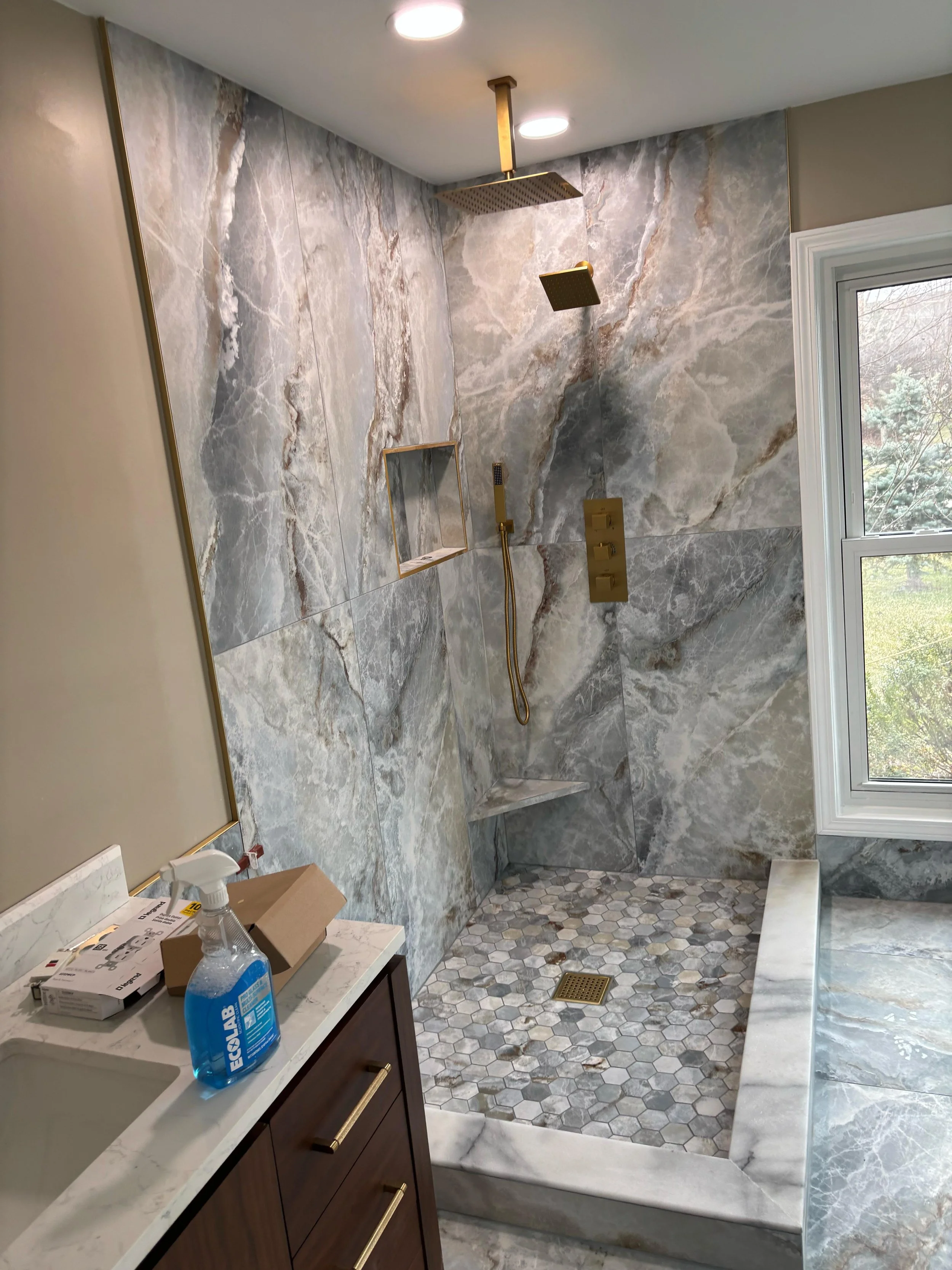 We transformed this bathroom into a luxurious retreat with a spacious walk-in shower, freestanding bathtub, custom tile intallation, and high-end finishes that blend comfort, style, and functionality.