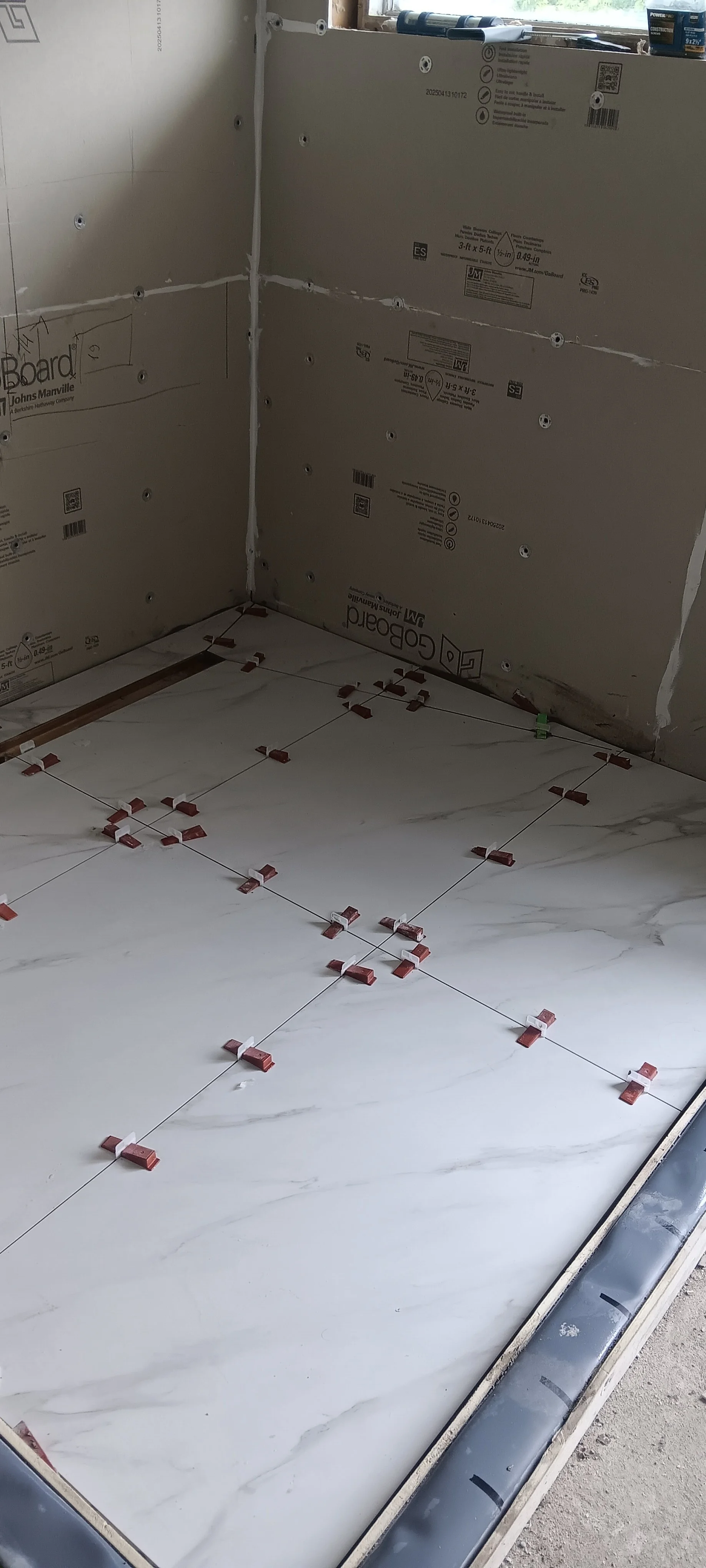 Close-up of the professionally installed mosaic shower floor and drain.