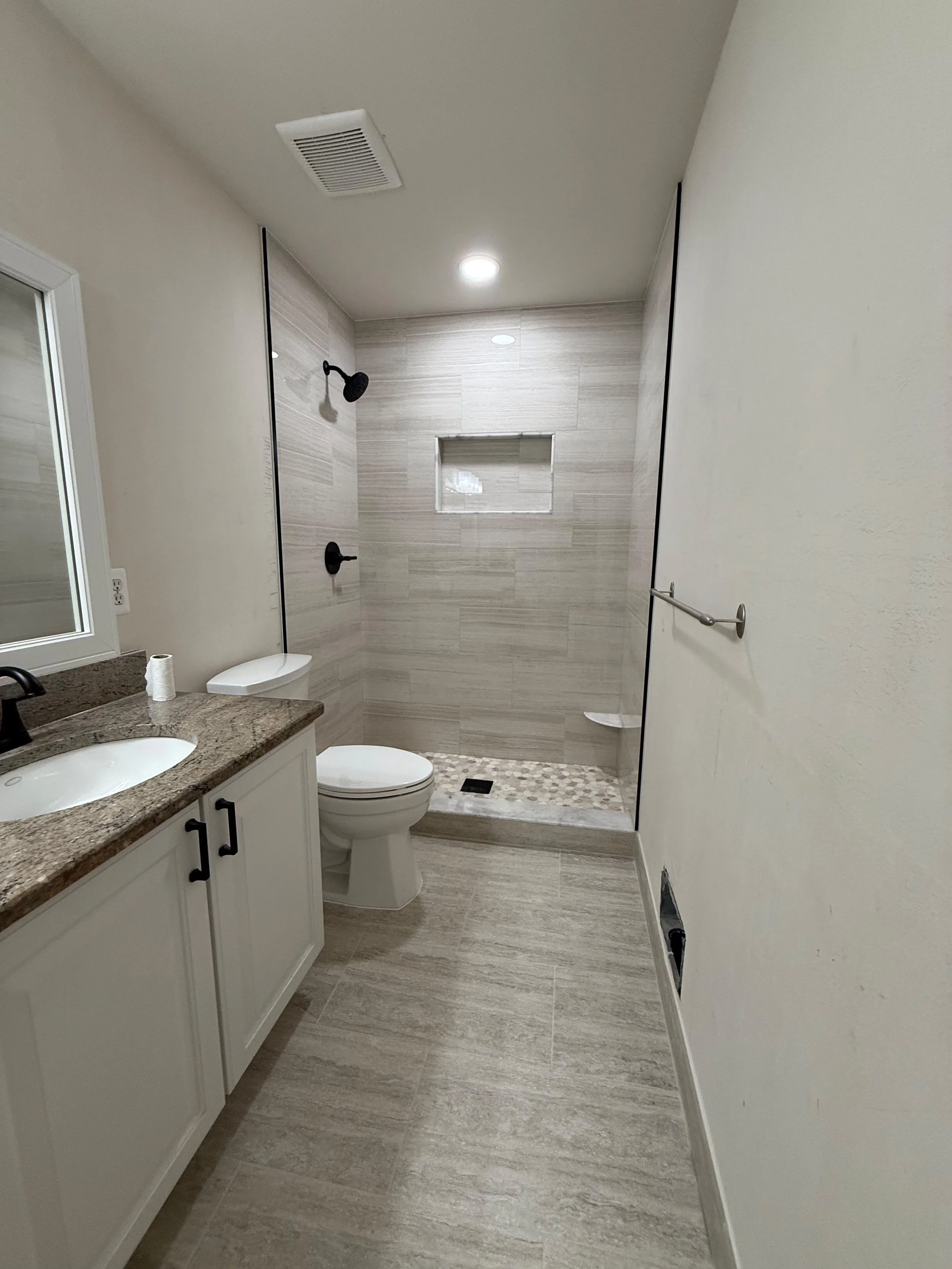 Complete bathroom renovation featuring a custom vanity, quartz countertop, modern tile flooring, and walk-in shower by Edilgjoni LLC in Southeast Michigan.