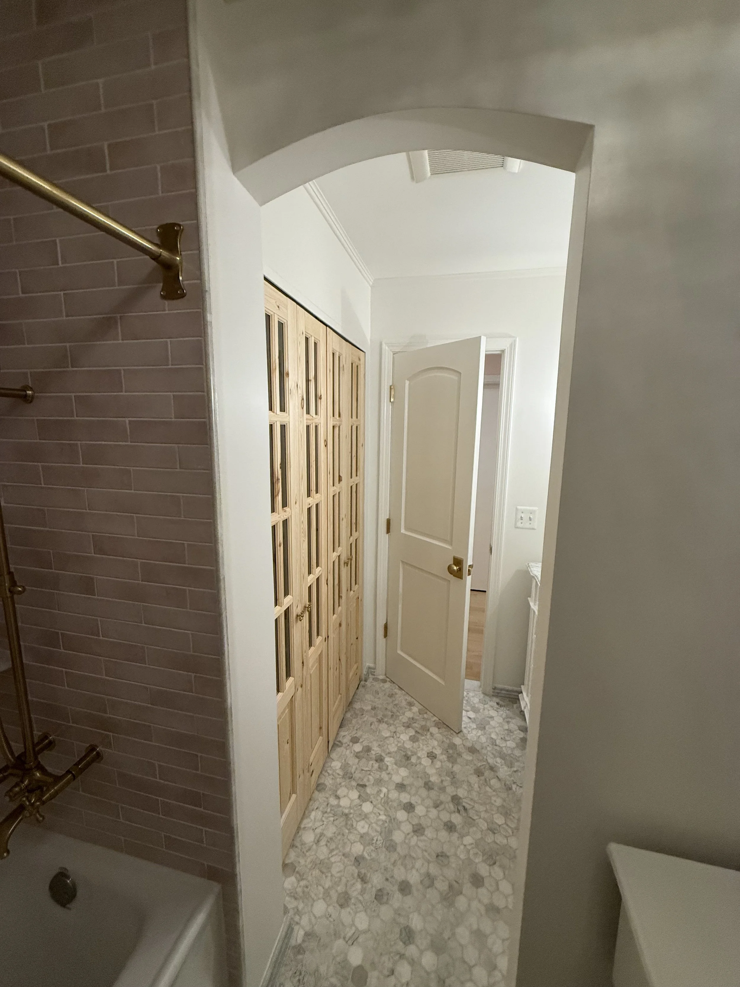 Full view of a Beverly Hills bathroom renovation featuring gray finishes, patterned flooring, and a wood glass-panel door.
