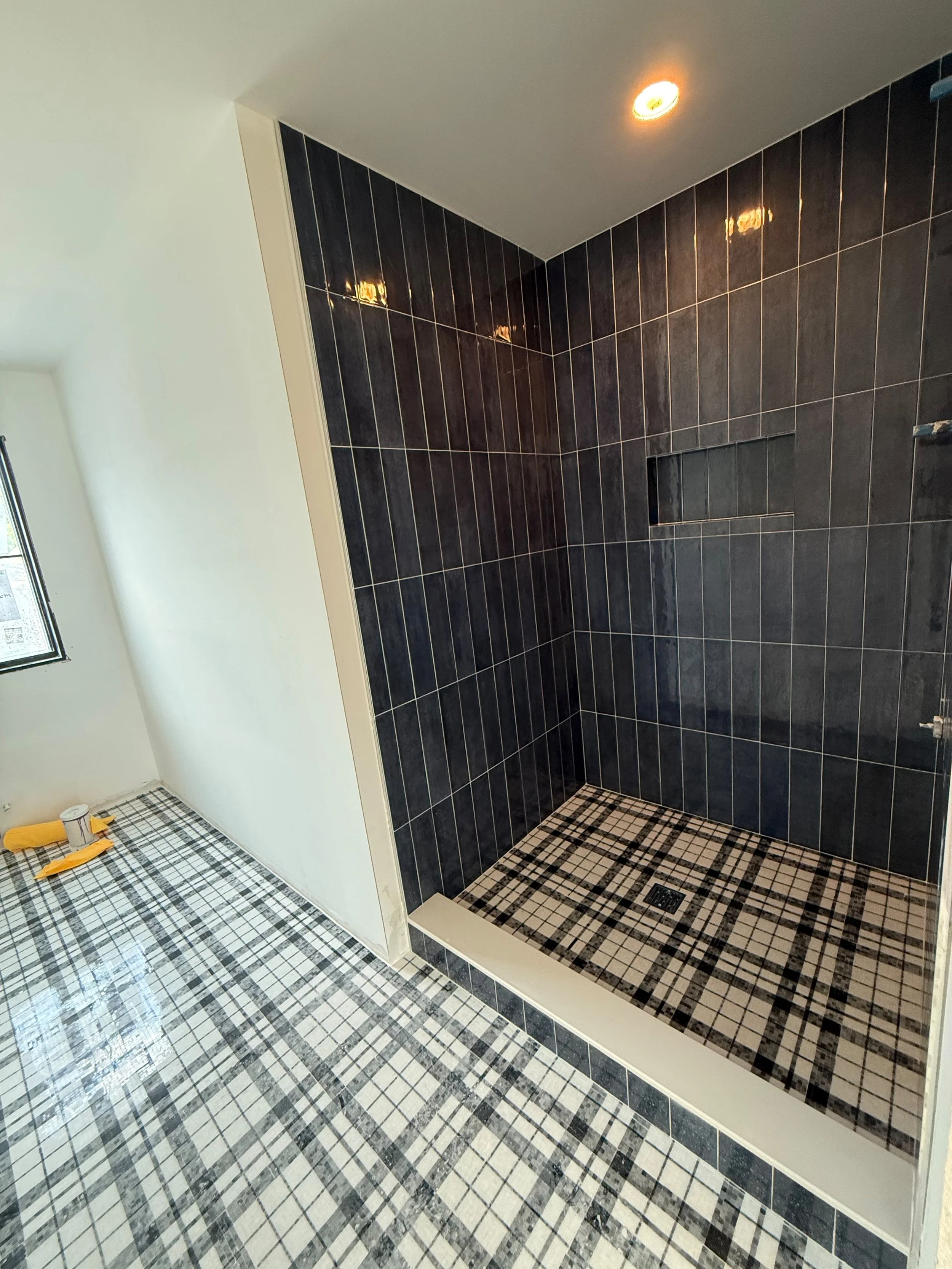 Elegant shower area with deep charcoal wall tile, an open entrance, clean architectural lines, and a contemporary finish that creates a bold visual contrast.
