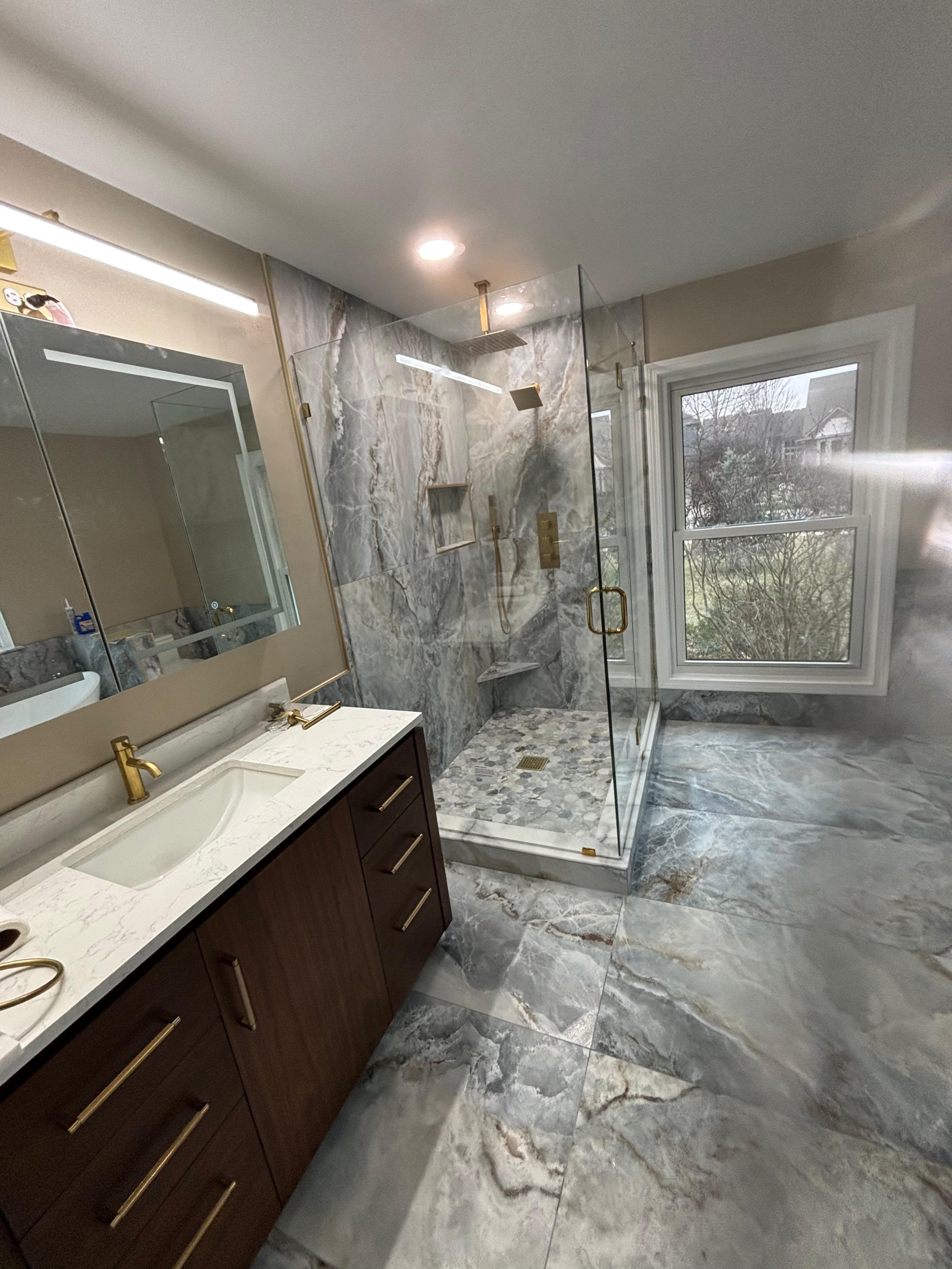 Designed for luxury and relaxation, this bathroom features a freameless glass shower, premium porcelain tile , custom shower niches, modern cabinetry, and high-end finishes that enhance both beauty and functionality.