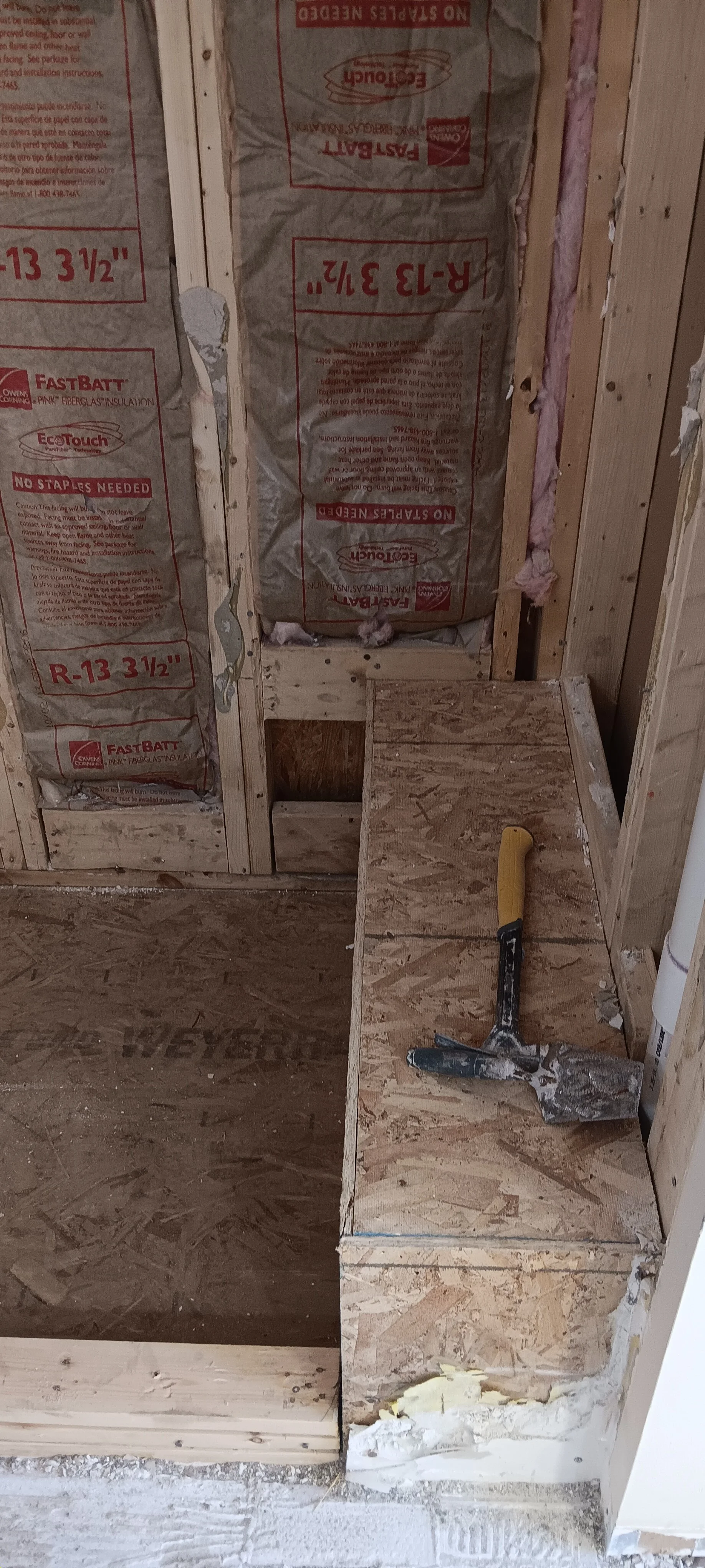Exposed shower framing and plumbing area before reconstruction.