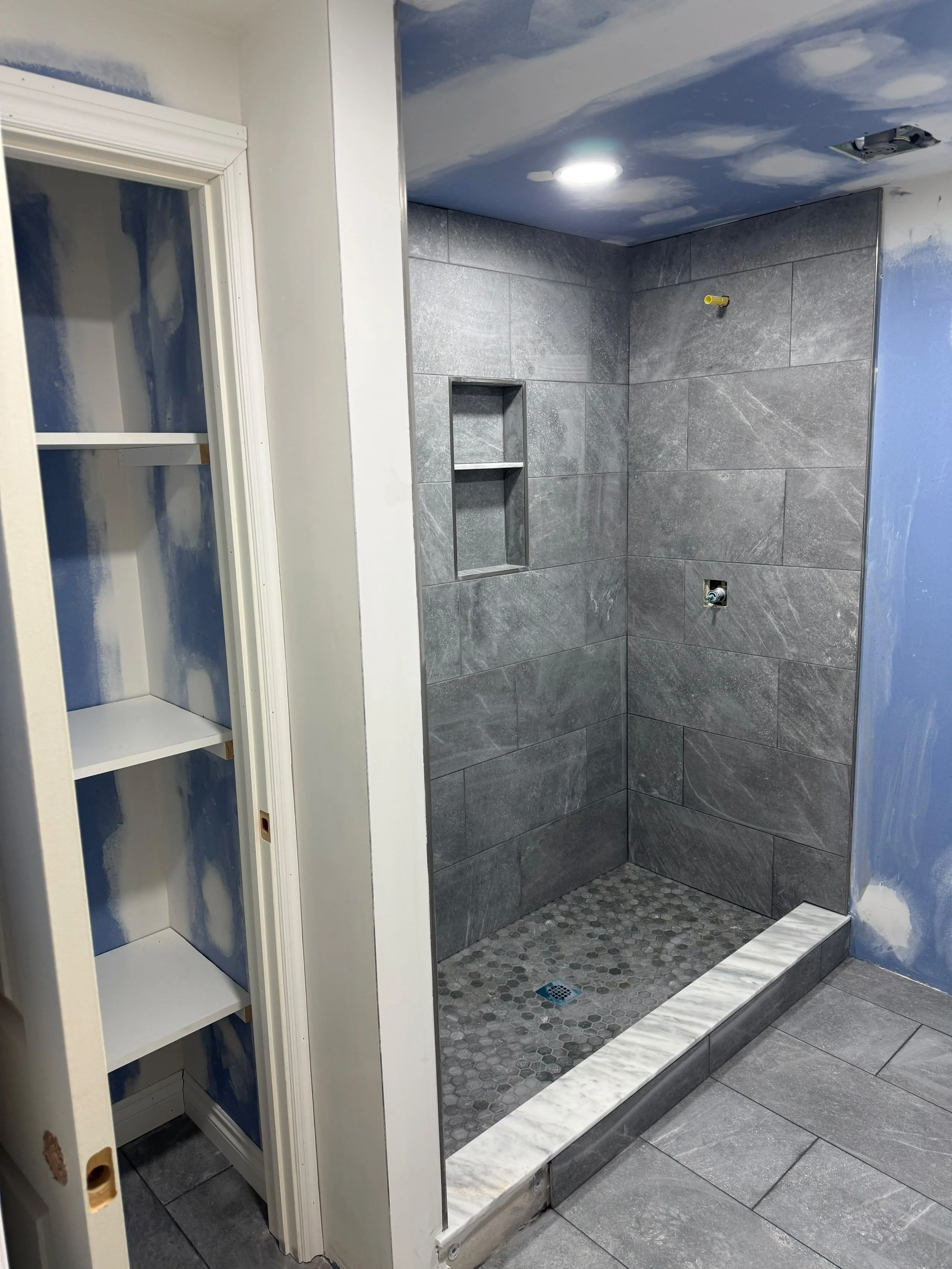 A spacious walk-in shower featuring precision tile installation, clean lines, and a durable waterproof design.