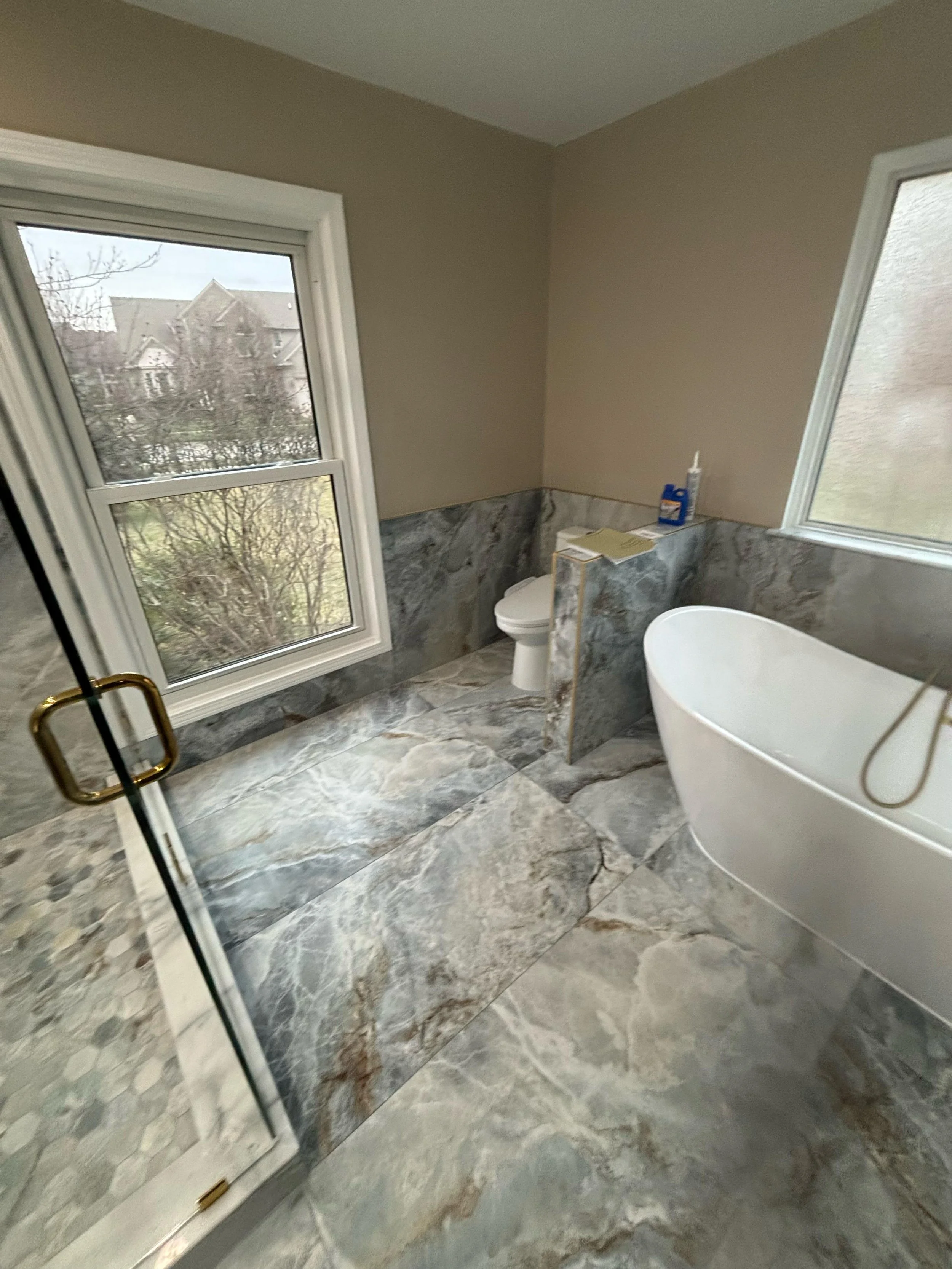 This elegant bathroom remodel features a freestanding soaking tub, custom walk-in shower, large-format natural stone-look tile, and premium finishes. Every detail was carefully crafted to create a relaxing, spa-inspired space with timeless beauty.