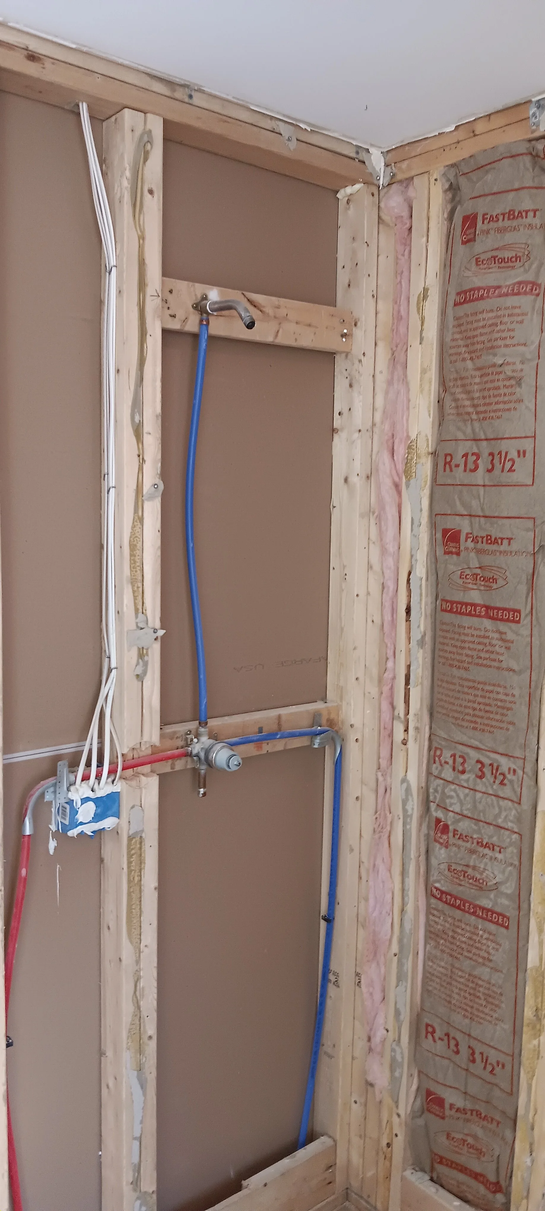 New shower framing with plumbing installed and space prepared for wallboard.