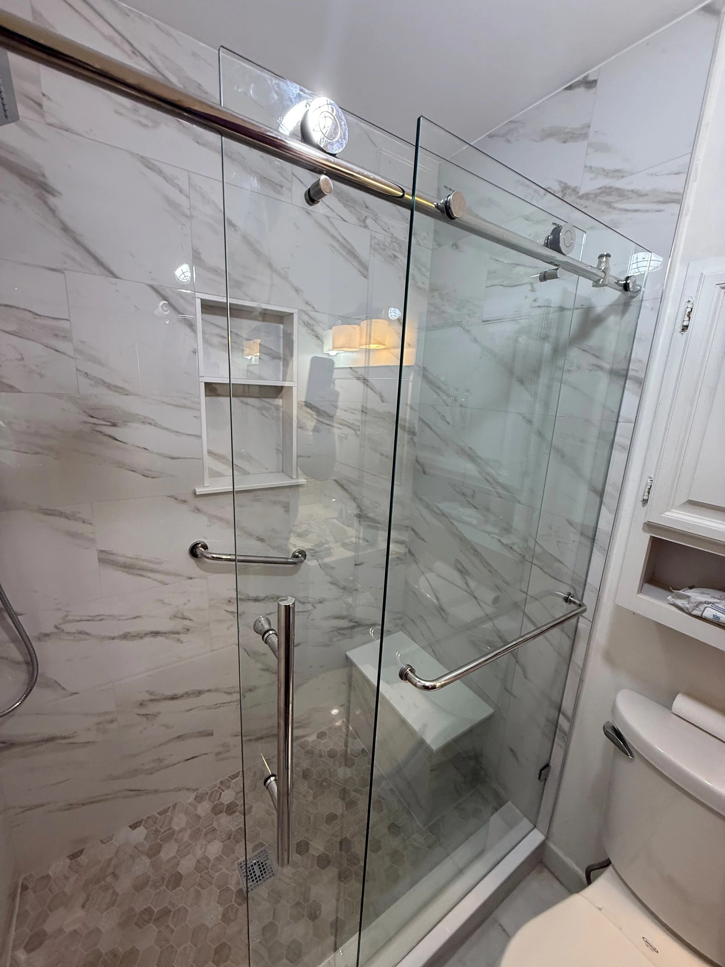 This renovation included a full bathroom redesign with a custom tile shower, frameless glass doors, waterproof construction, and modern finishes that maximize comfort, style, and functionality.