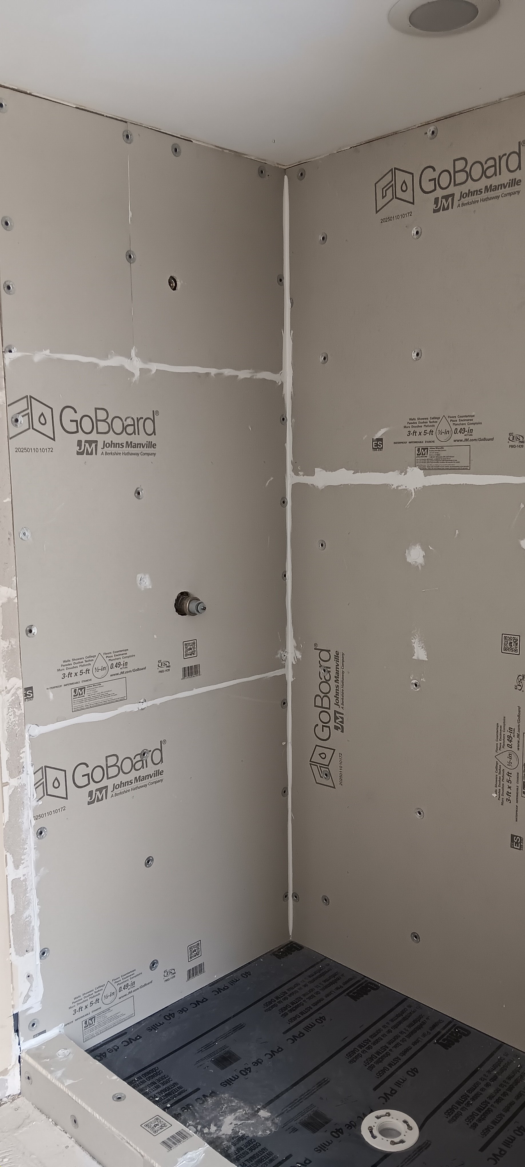 Cement-board shower walls installed with a built-in storage niche.