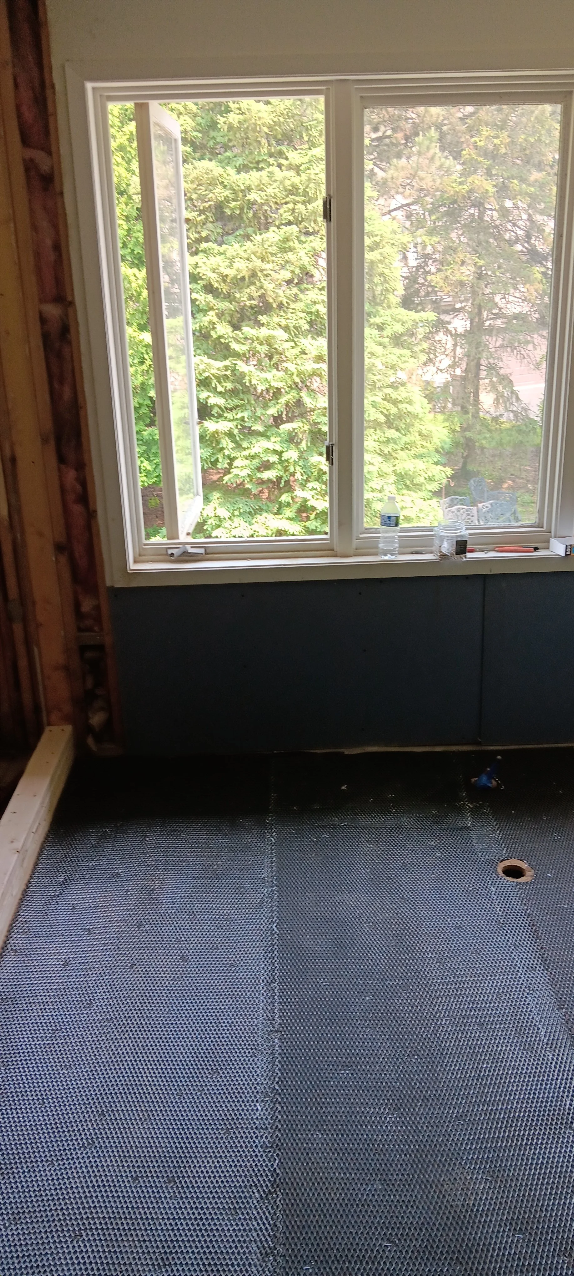 Renovation bathroom space taking shape with updated walls and flooring.