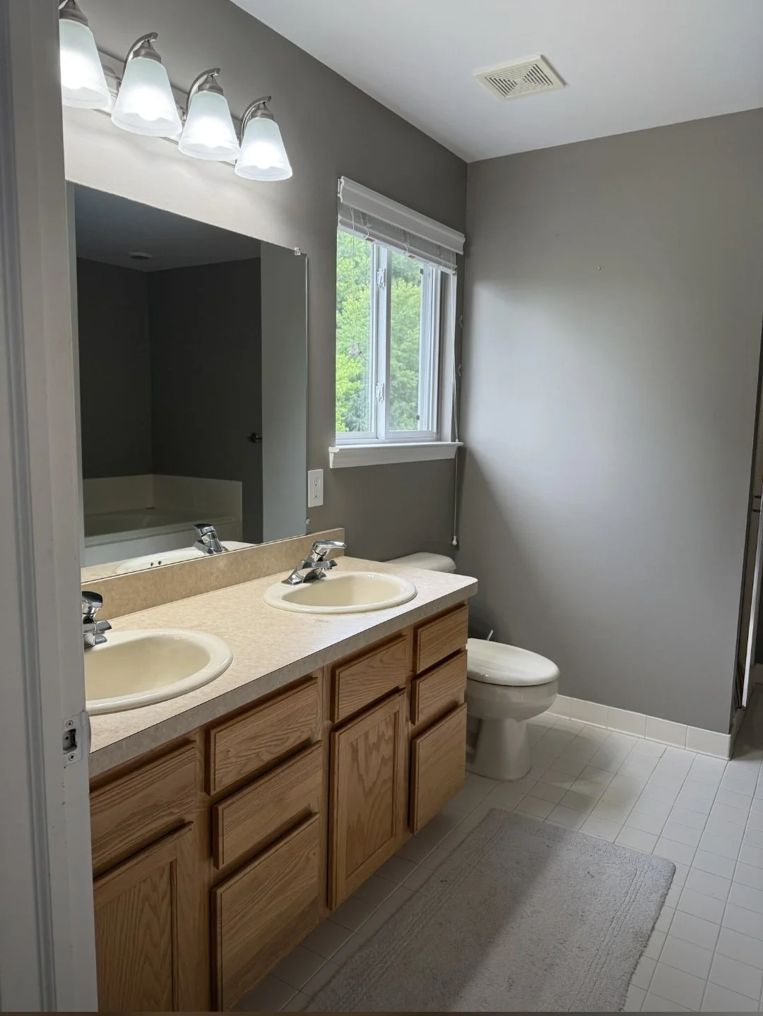The spacious vanity area combines beautiful cabinetry, a large mirror, and quality finishes to provide both elegance and practicality.