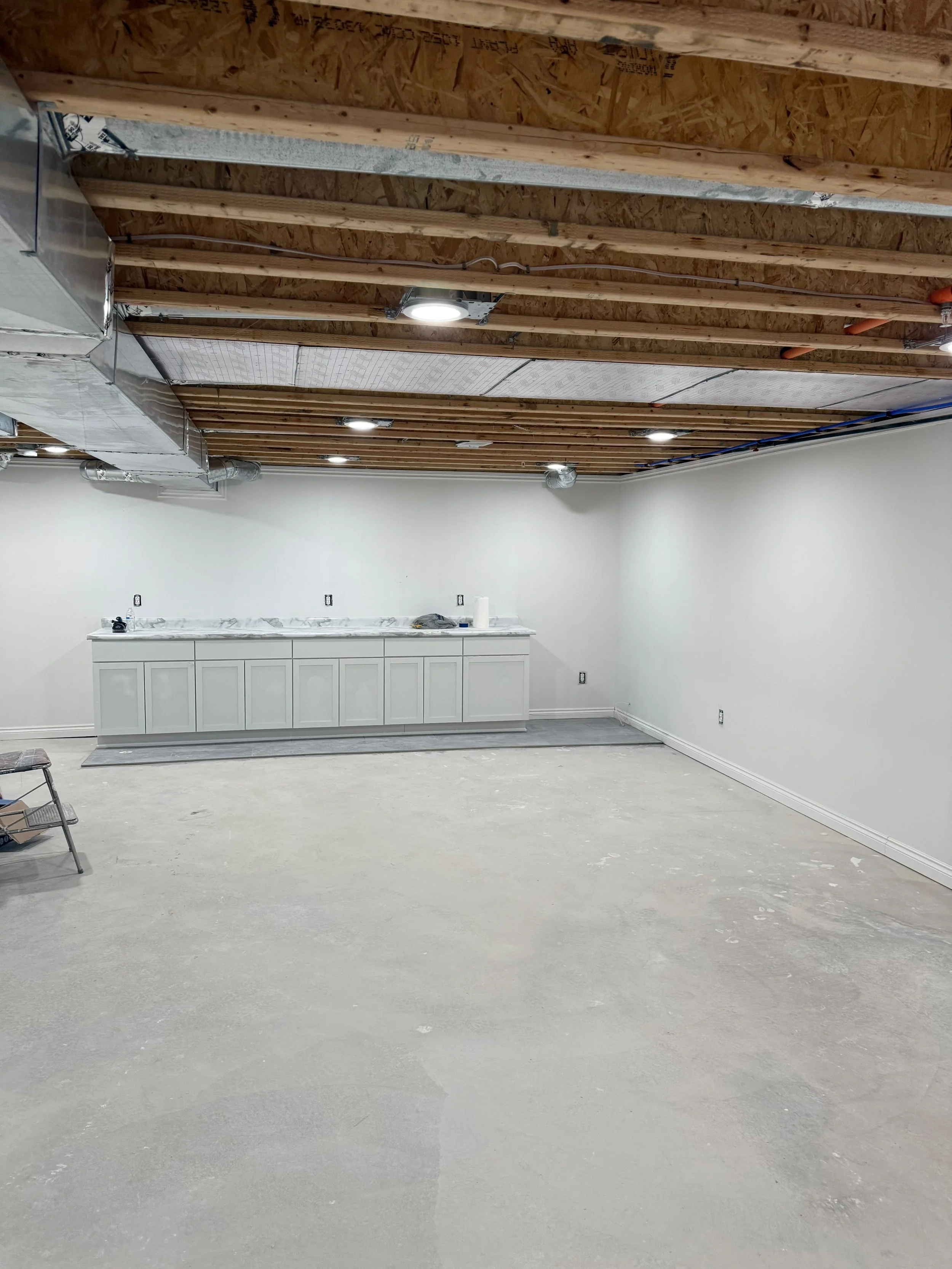 A large open-concept basement designed to provide flexible space for a family room, home ì, gym, office, or entertainment area.