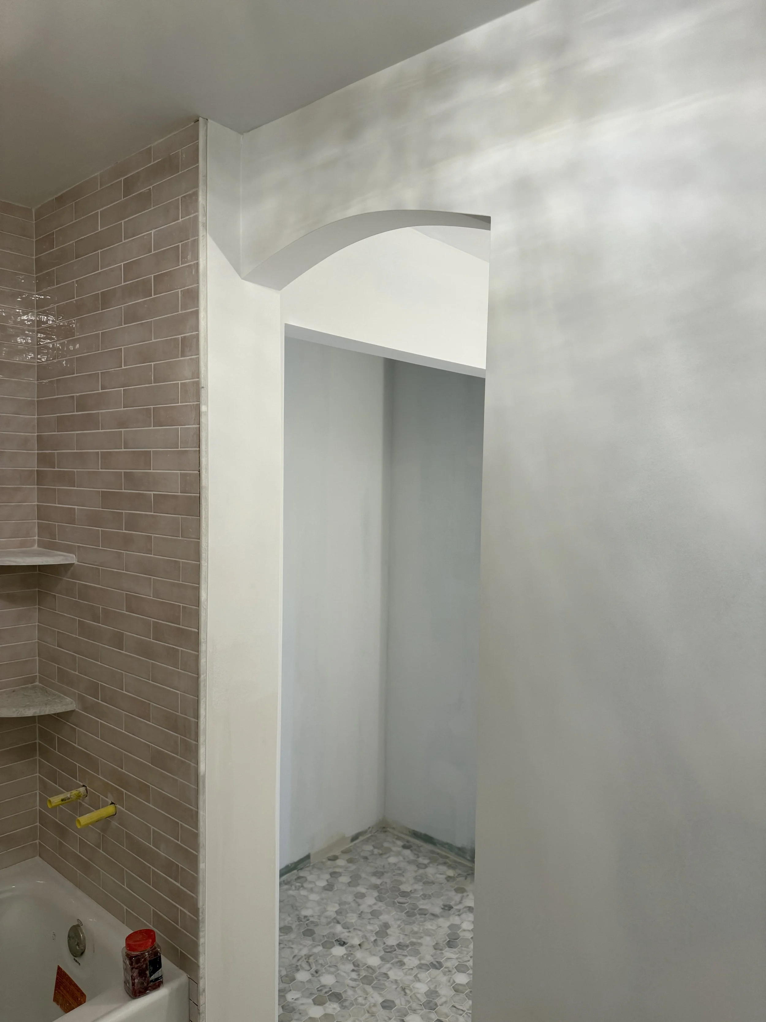 Newly remodeled walk-in shower with gray wall tile and a patterned mosaic floor in Beverly Hills, Michigan.
