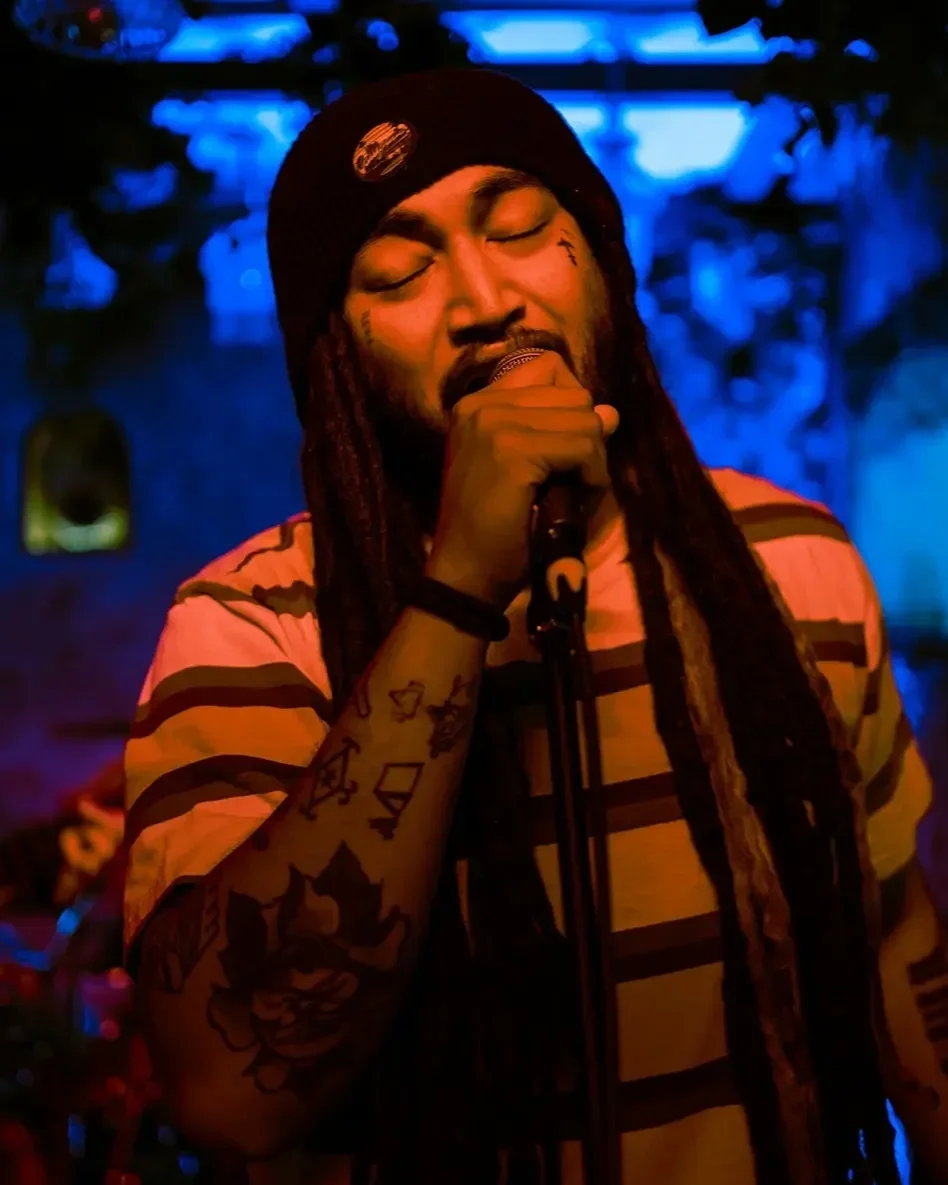 Dread Kennedy in a dimly lit room with blue lighting.