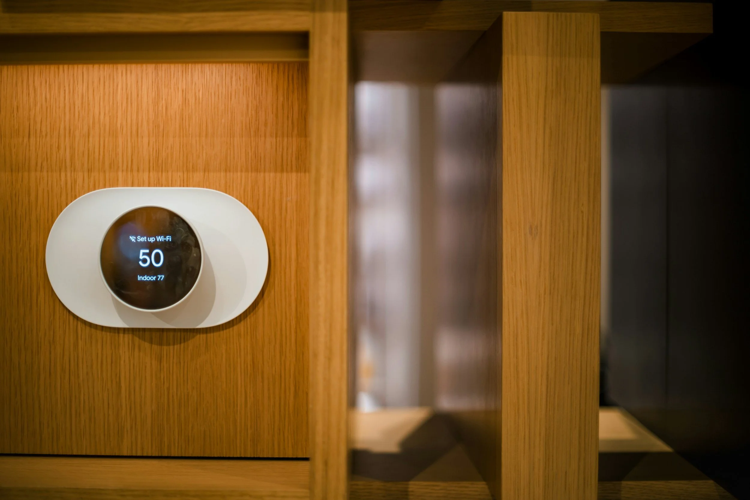 Close-up of a digital thermostat or control device on wooden furniture, displaying Wi-Fi setup status, with a black screen and white text.