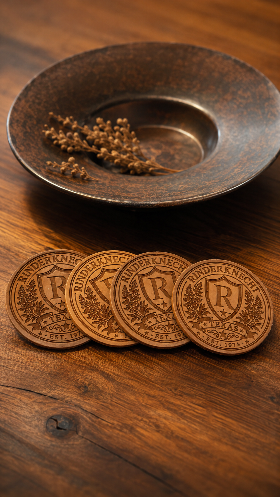 Four copper-colored coins aligned in front of a rustic black bowl with dried plant stems inside on a wooden surface.