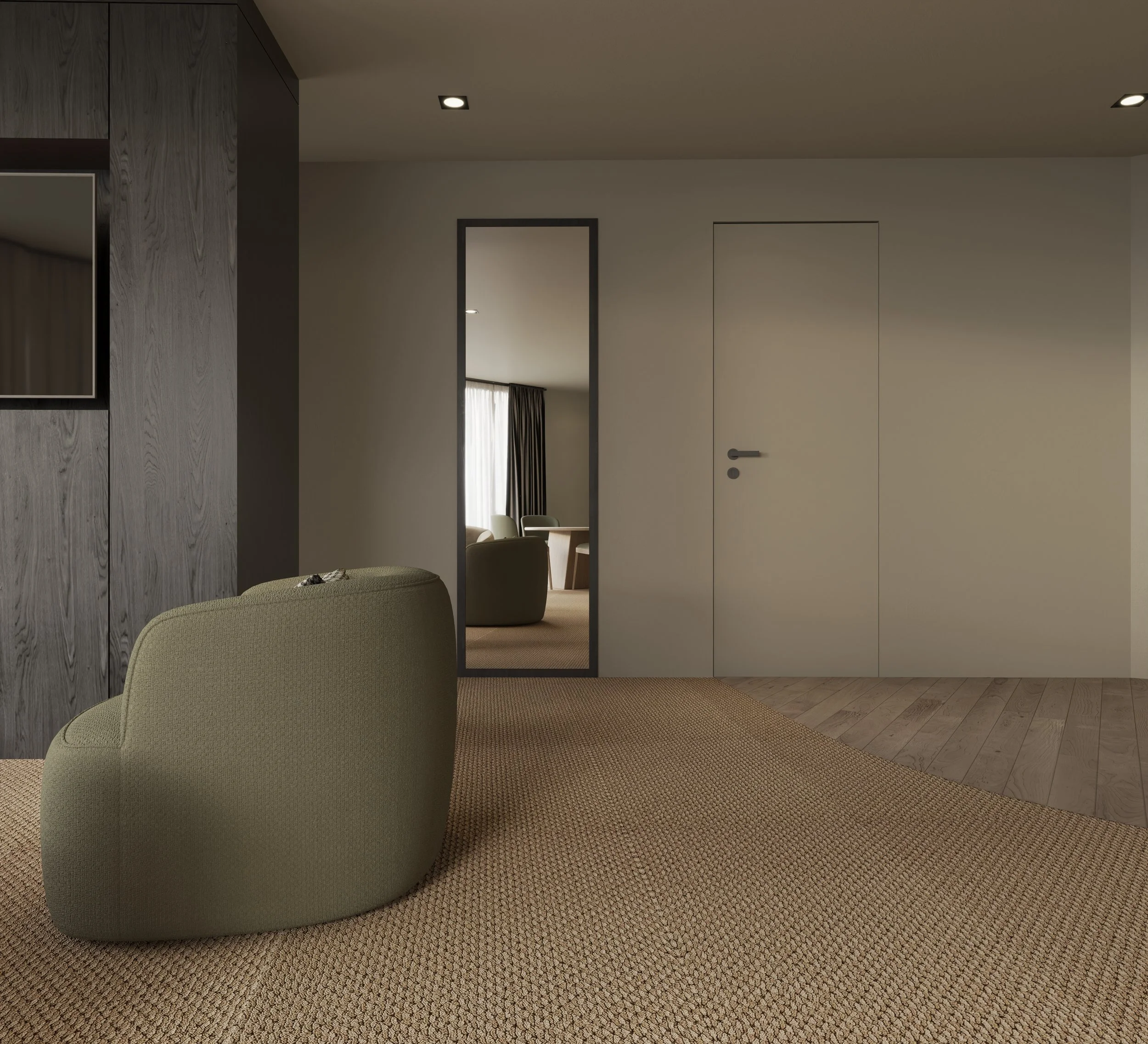 A room with beige carpet, a green armchair, wooden walls, and a doorway leading to a space with a window and a dining area with chairs and a table.