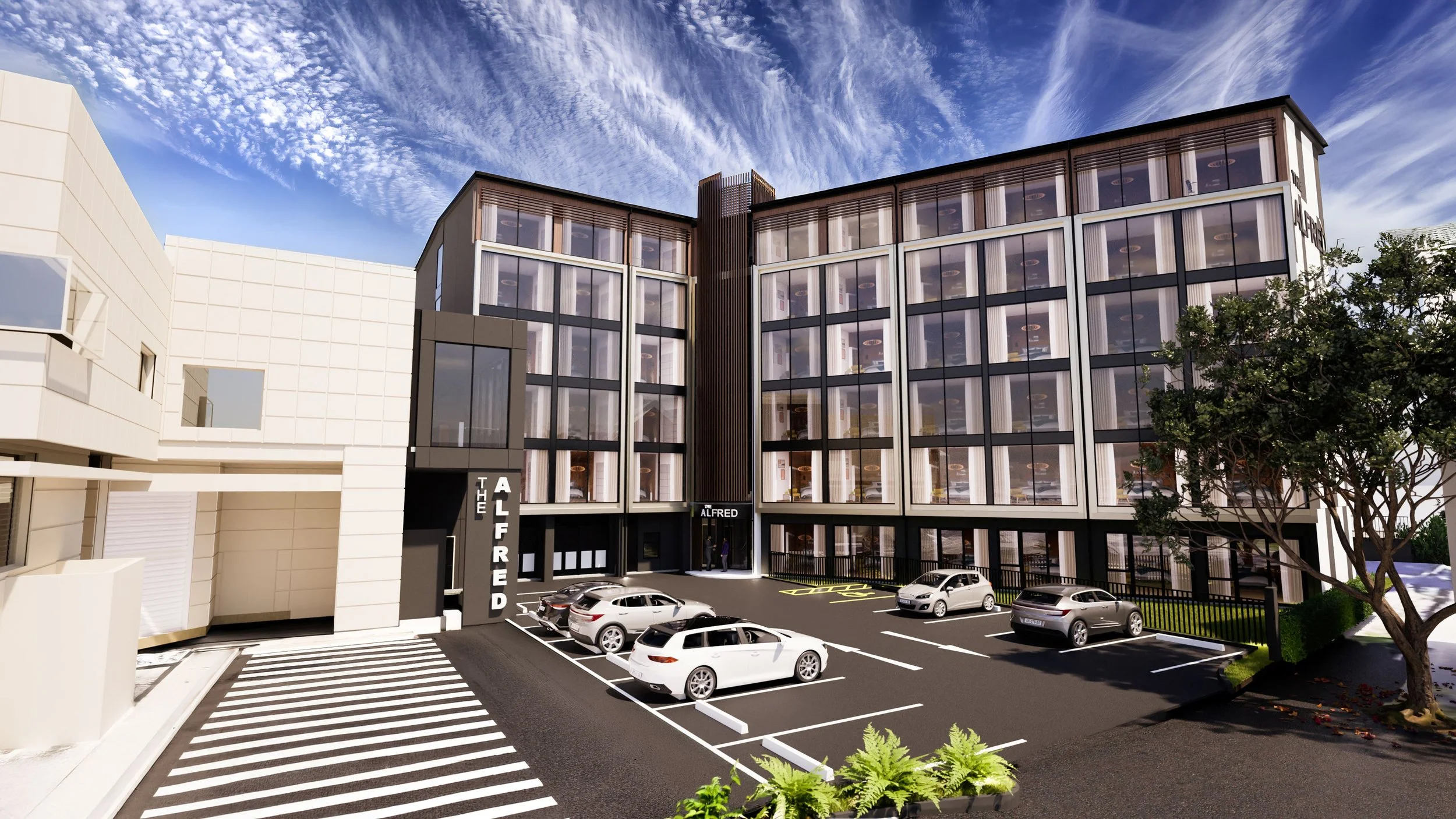 Modern multi-story building with glass windows and parking lot in front, featuring white, black, and beige exterior walls and a tree on the right side.