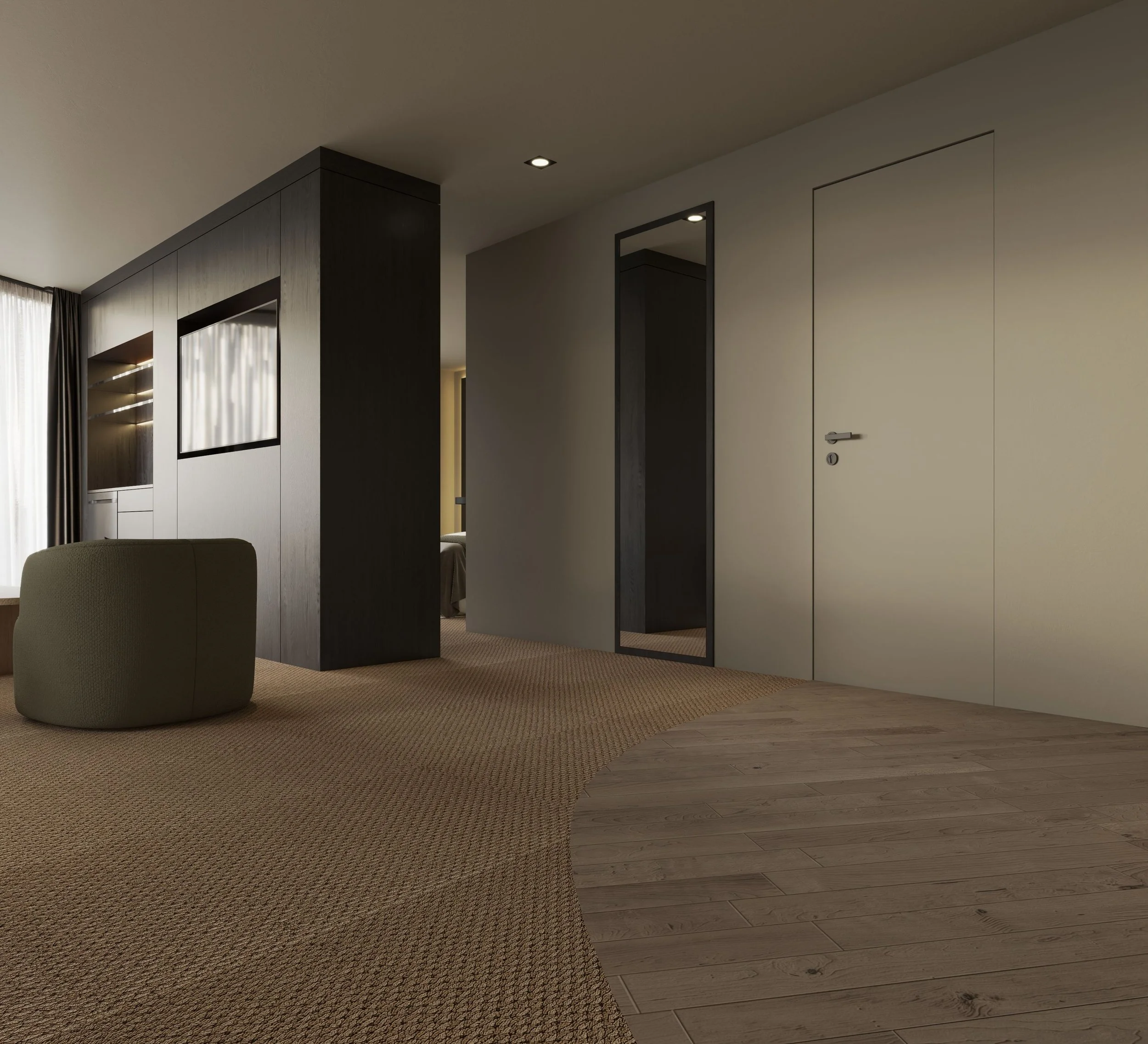 Interior view of a modern room with beige carpet, a small section of wooden flooring, a green upholstered chair, a dark partition wall with built-in shelves, a mirror, and a door on the right side.