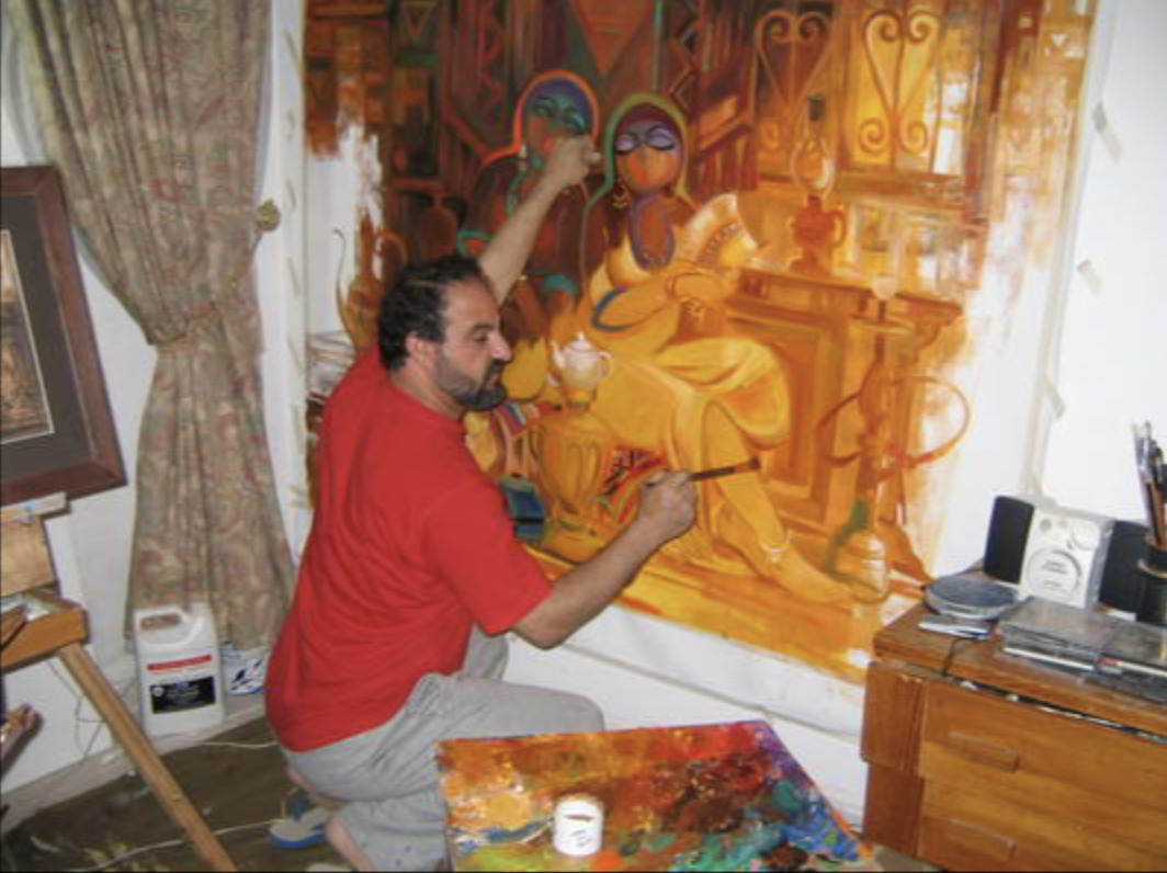 An artist painting an abstract scene of two women in yellow dresses with glasses and headscarves, sitting in a cozy interior with candles.