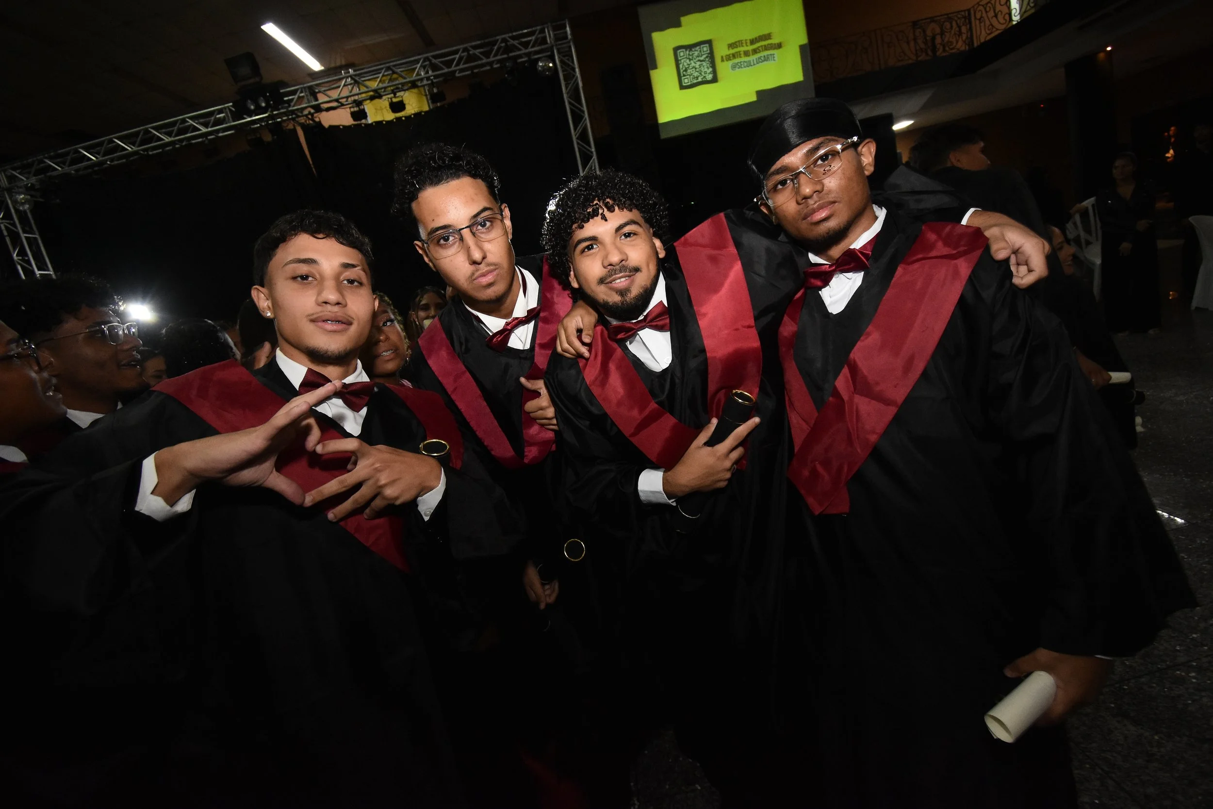 Grupo de jovens do colegial usando beca de formatura, em sua colação de grau