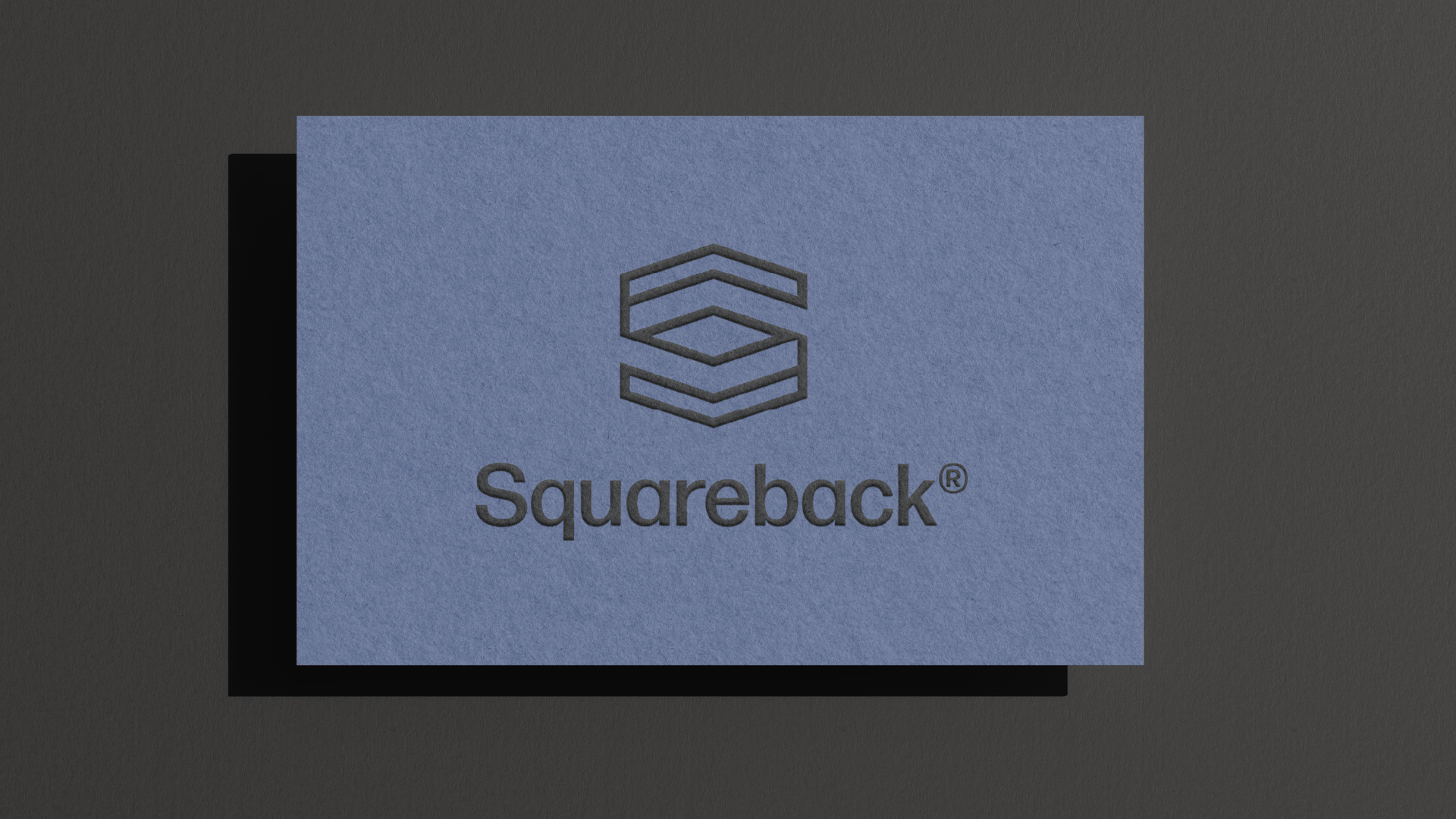 Blue square with the black logo of a hexagon made of three stacked lines and the word "Squareback" underneath, on a dark surface.