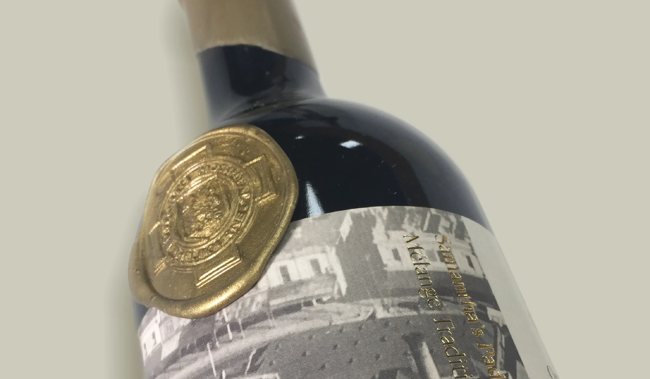 Close-up of a wine bottle with a gold foil capsule and a partially visible label.