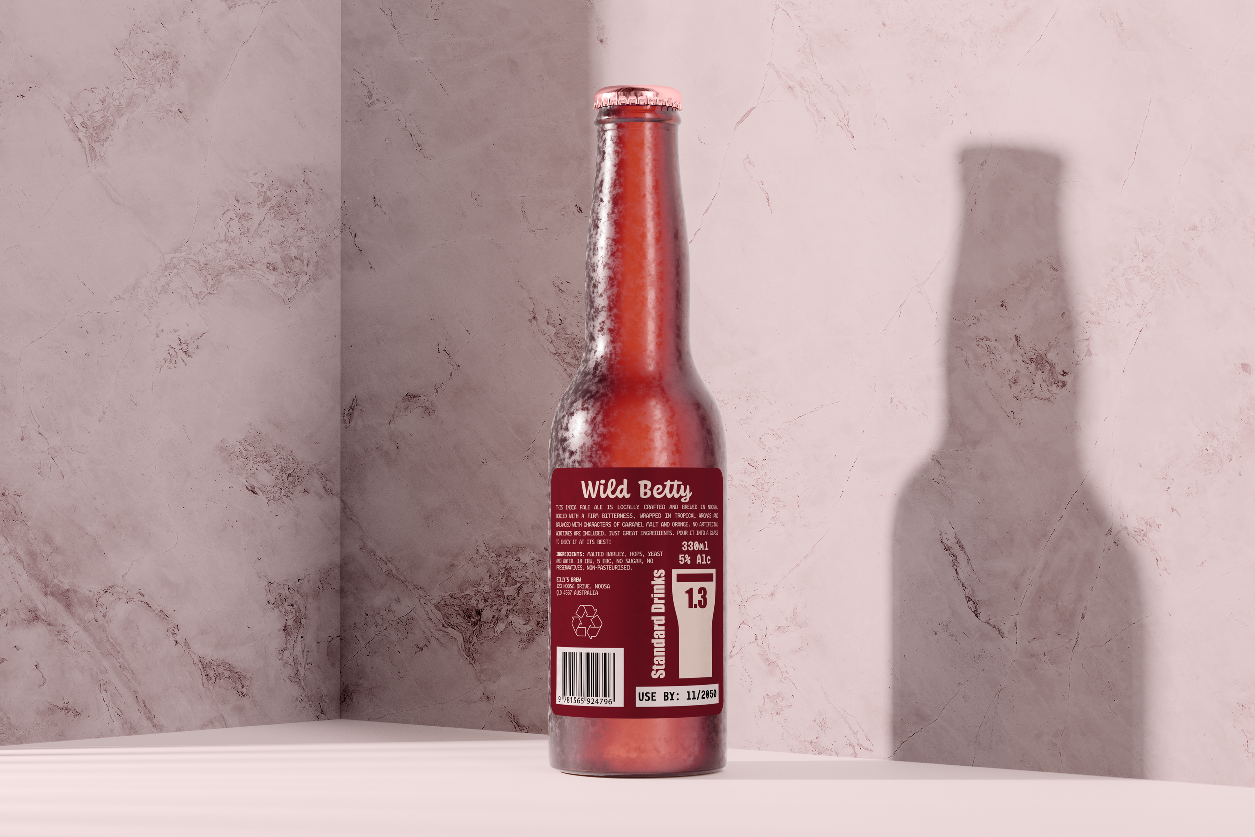 A bottle of Wild Betty IPA standing on a white surface against a pinkish textured wall with a shadow cast on the right side.