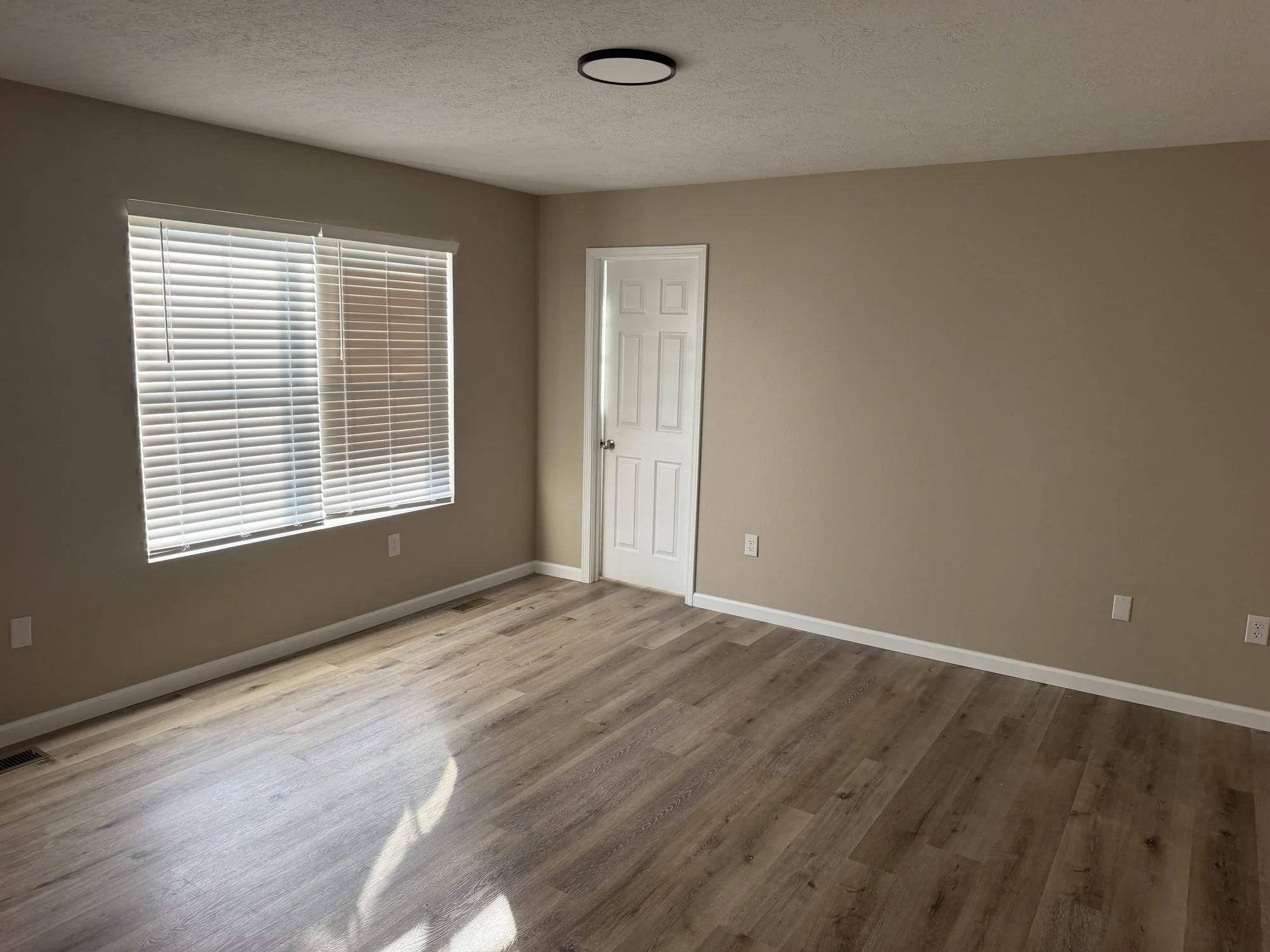  Spacious living area with laminate floors and neutral walls, Lebanon MO townhouse rental. 