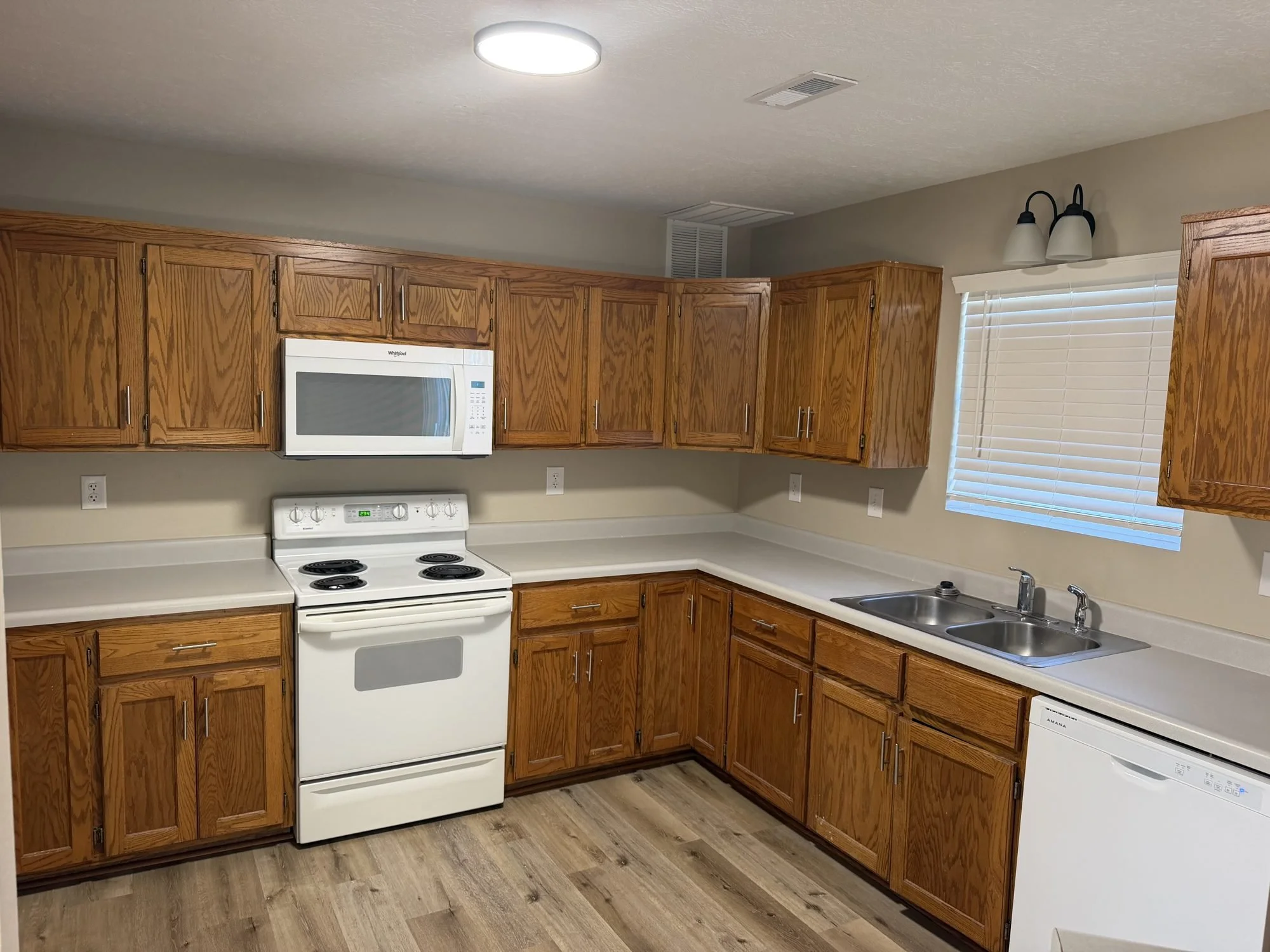  Kitchen with oak cabinets, electric range, and microwave, Lebanon MO townhouse for rent. 