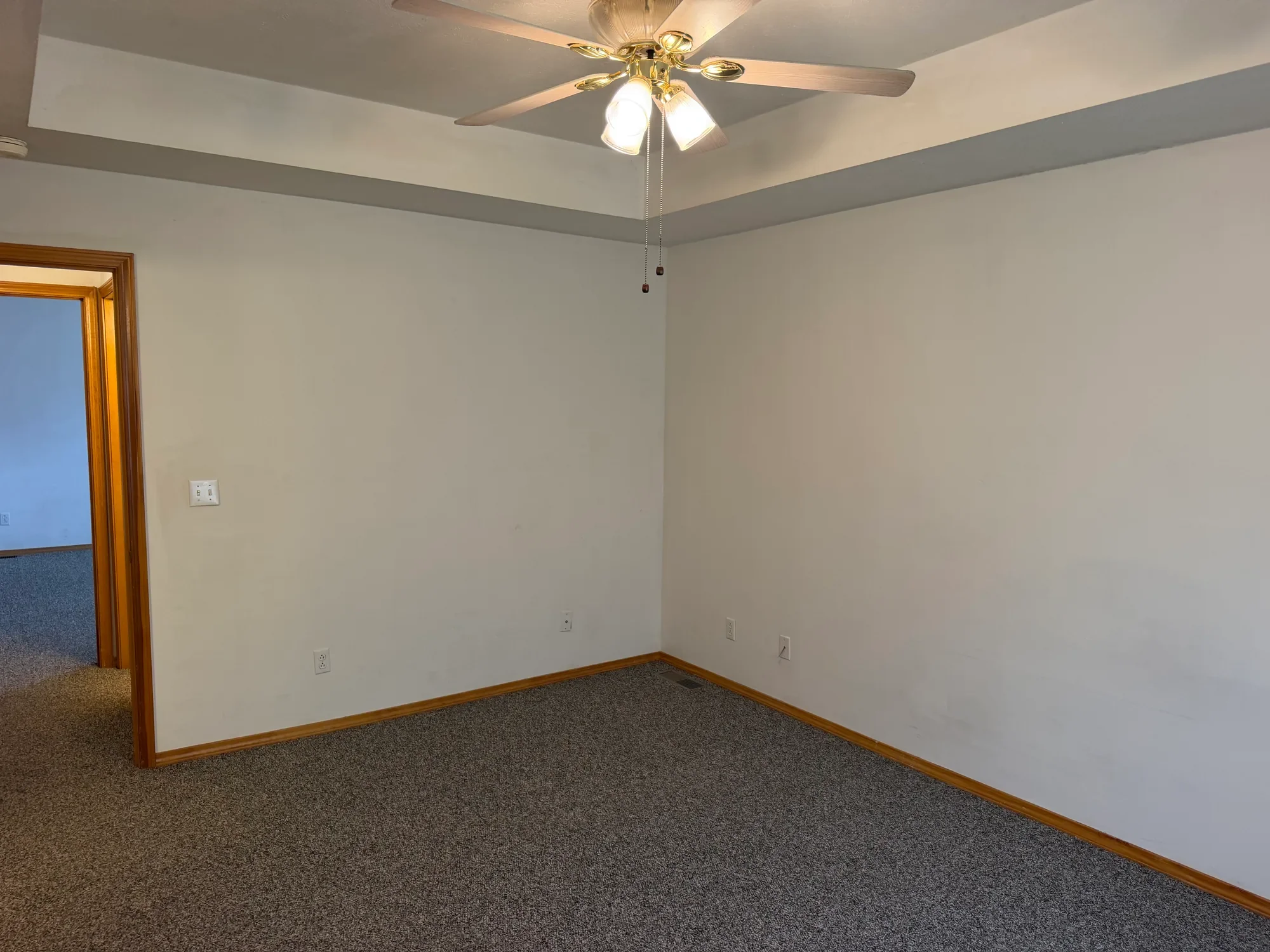  Bedroom with tray ceiling and ceiling fan, door to hallway 