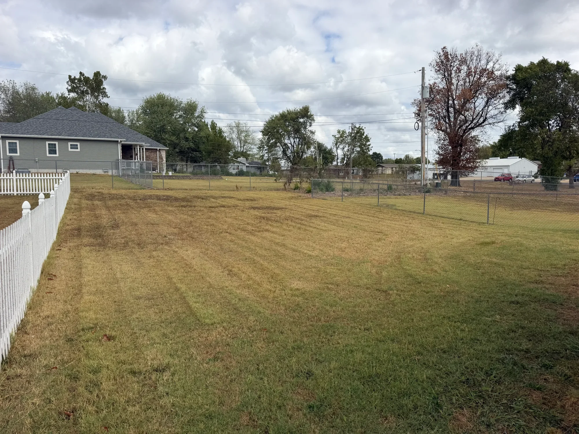  Large grassy backyard with white fence 