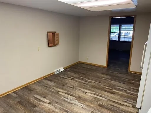  dining area: Open dining area next to the kitchen with wood-look flooring and a doorway to another room 