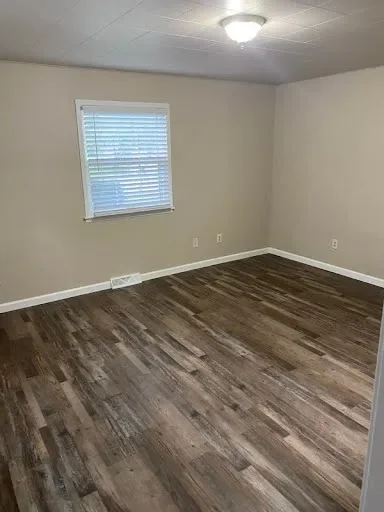  Bedroom with a window with blinds and dark wood-look flooring 