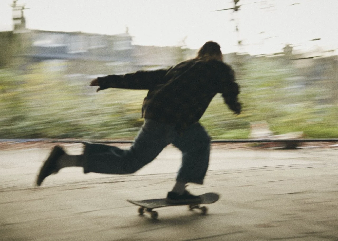 Person skateboarding indoors with a blurred background.