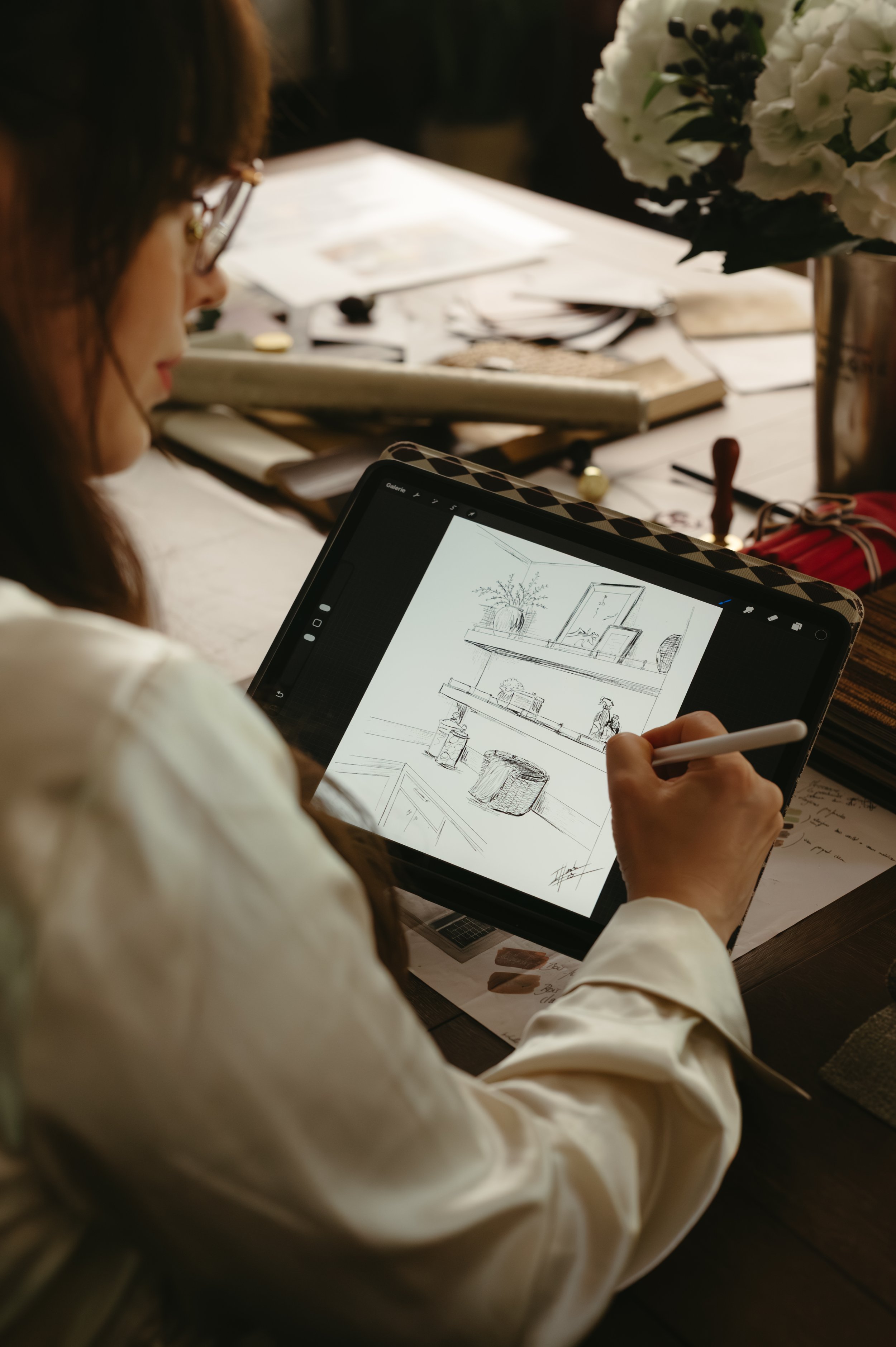 Iris Humbert working on a hand-drawn interior design sketch at her desk. Every element is thoughtfully considered and tailored to the space, creating a refined interior designed uniquely around the client’s vision.