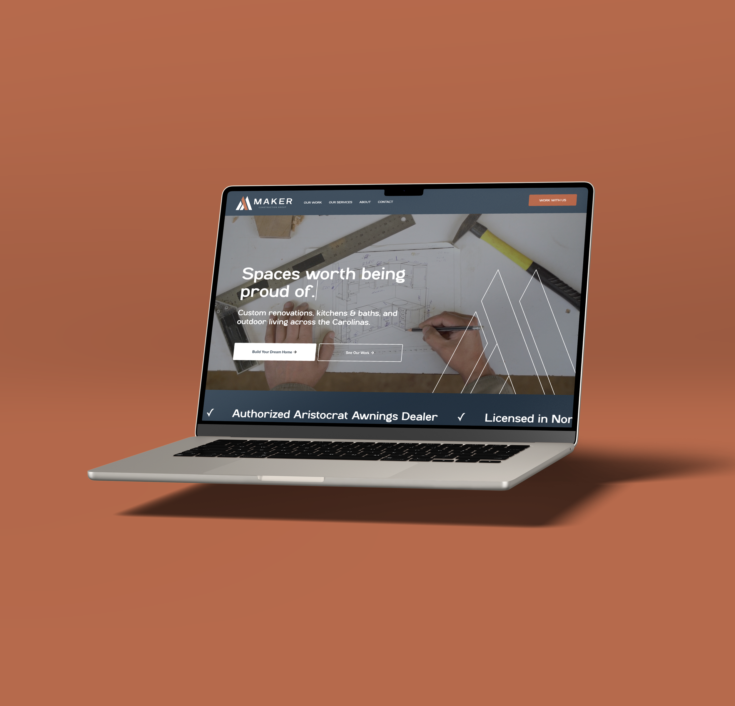 Partial view of a laptop screen displaying a construction company's website on a brown background.
