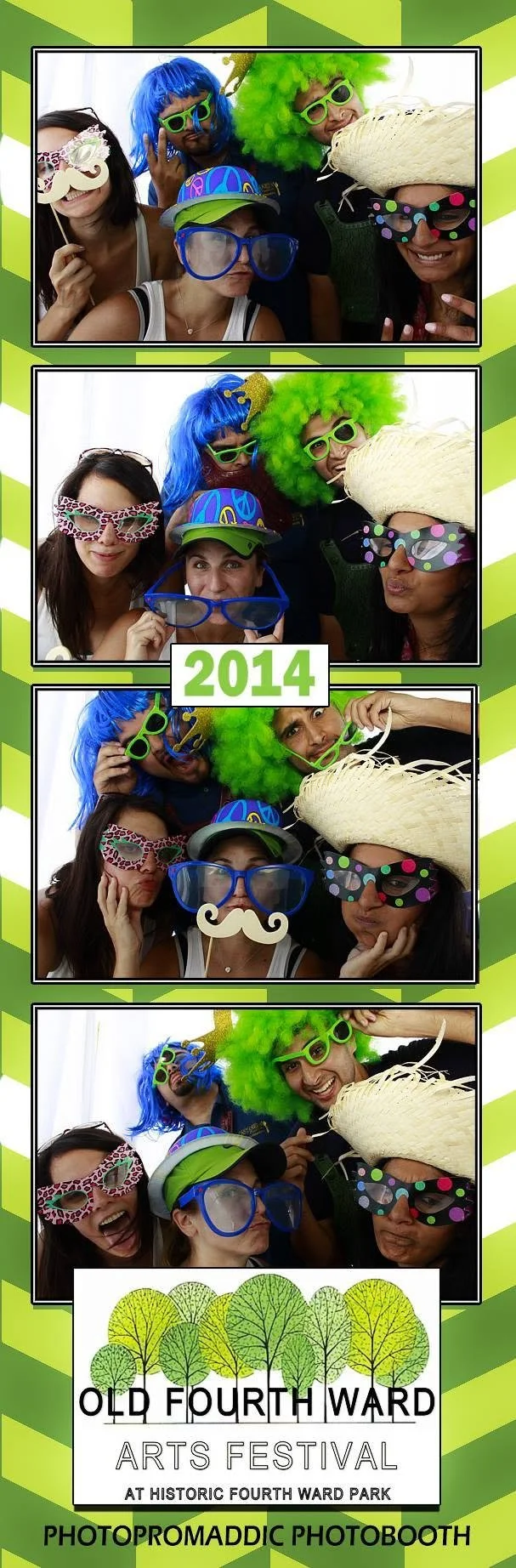 A group of five women in a photo booth wearing colorful costumes, wigs, and fun accessories, celebrating the 2014 Old Fourth Ward Arts Festival at Historic Fourth Ward Park.