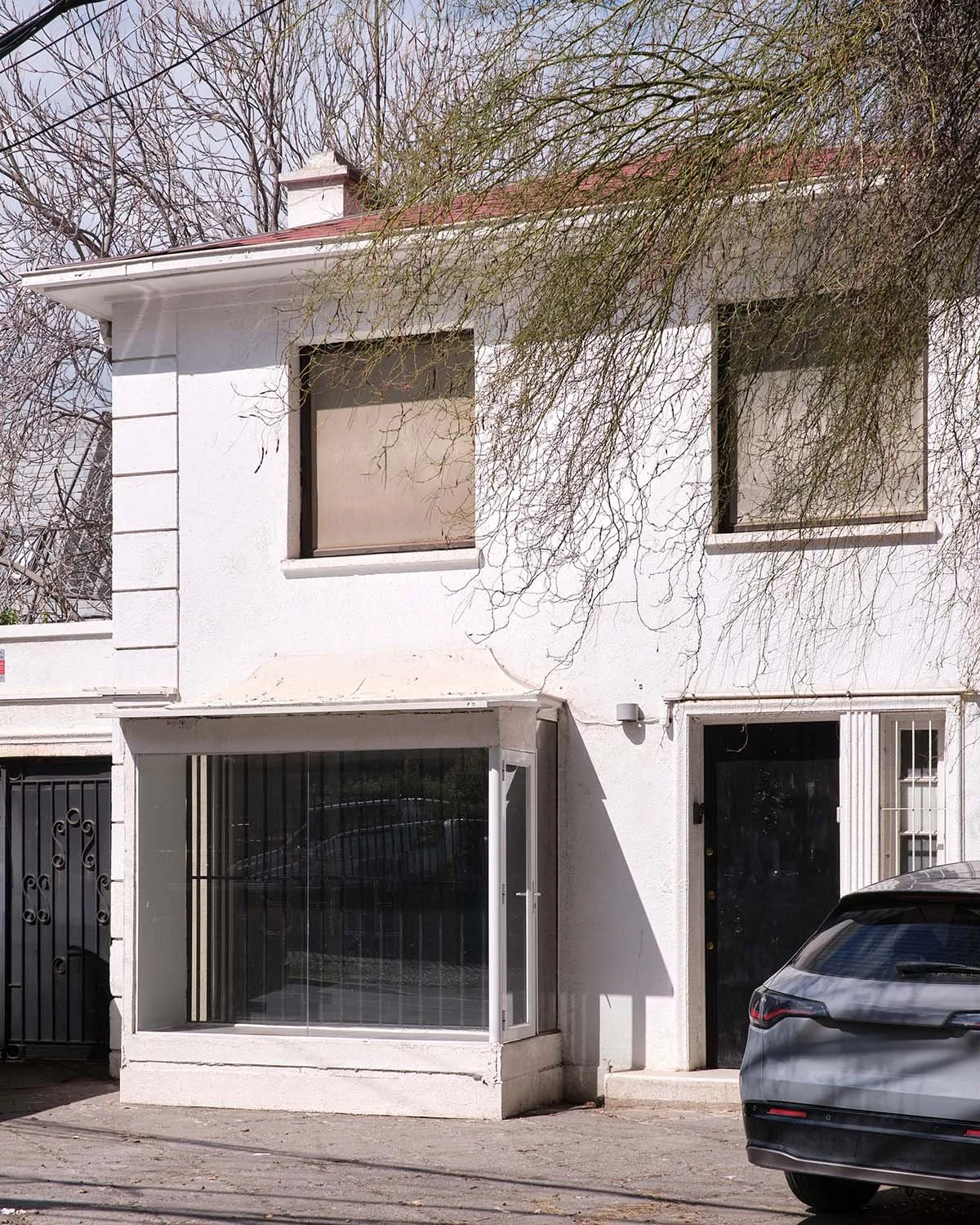 Fachada norte y antejardín de la casa aislada en Renato Sánchez