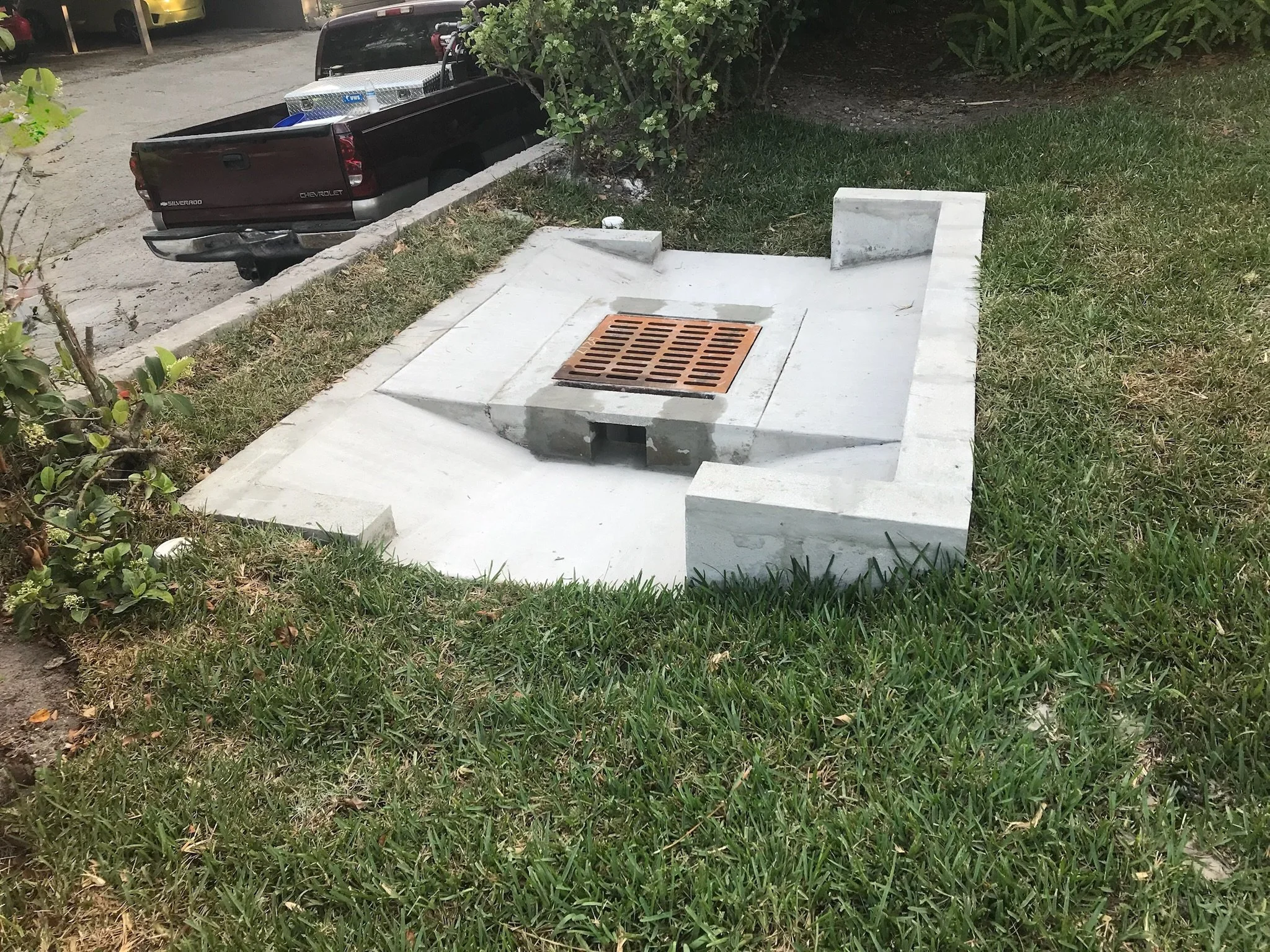 Newly constructed drainage inlet top with apron and retaining walls.