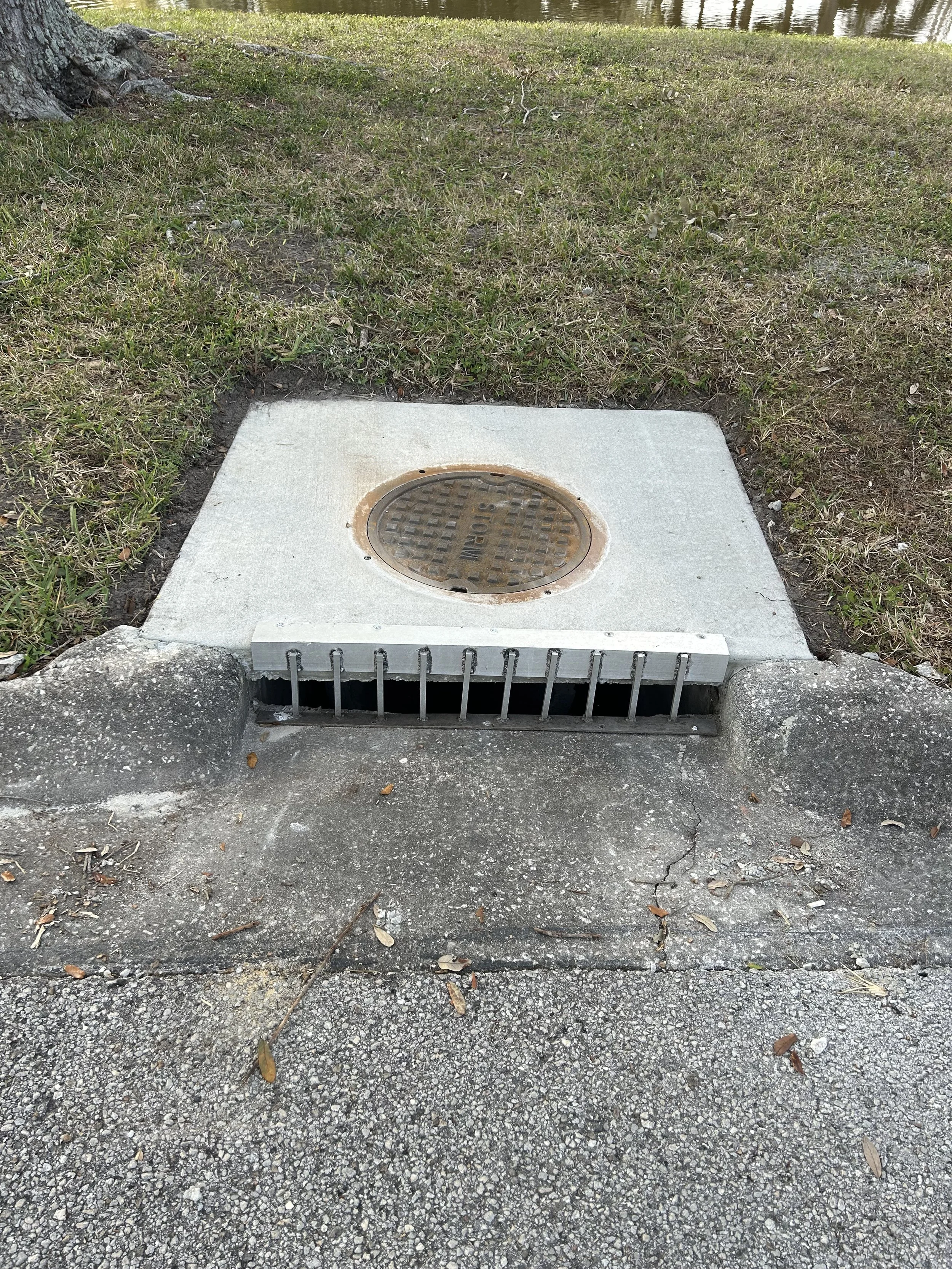 A  newly installed drainage structure top with manhole cover.