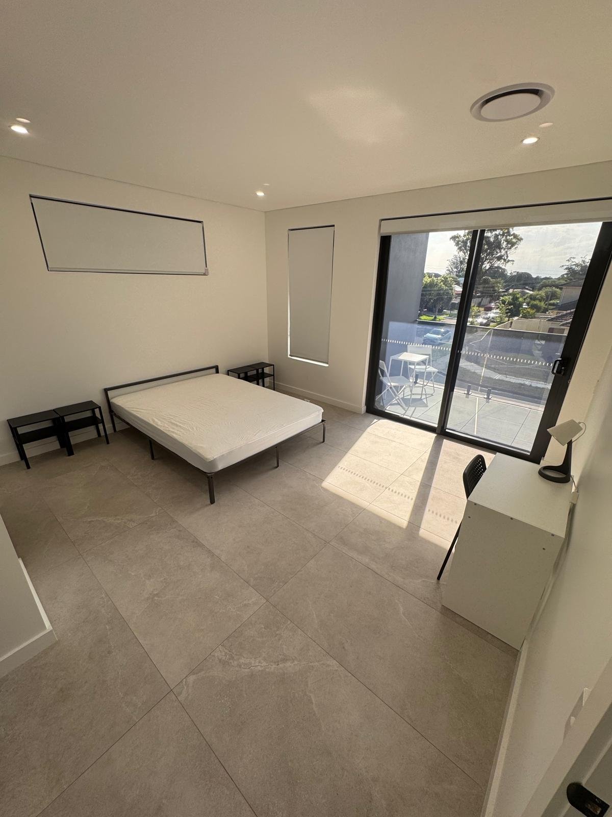 Furnished co-living bedroom with bed, wardrobe and workspace in Sydney
