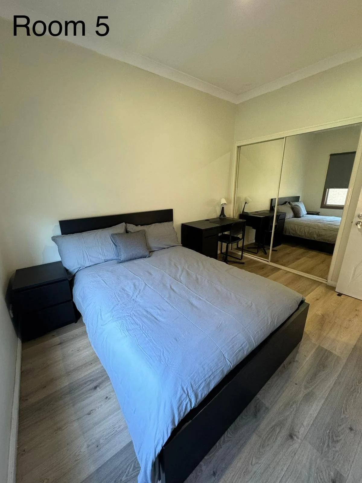 Furnished co-living bedroom with bed, wardrobe and workspace in Sydney