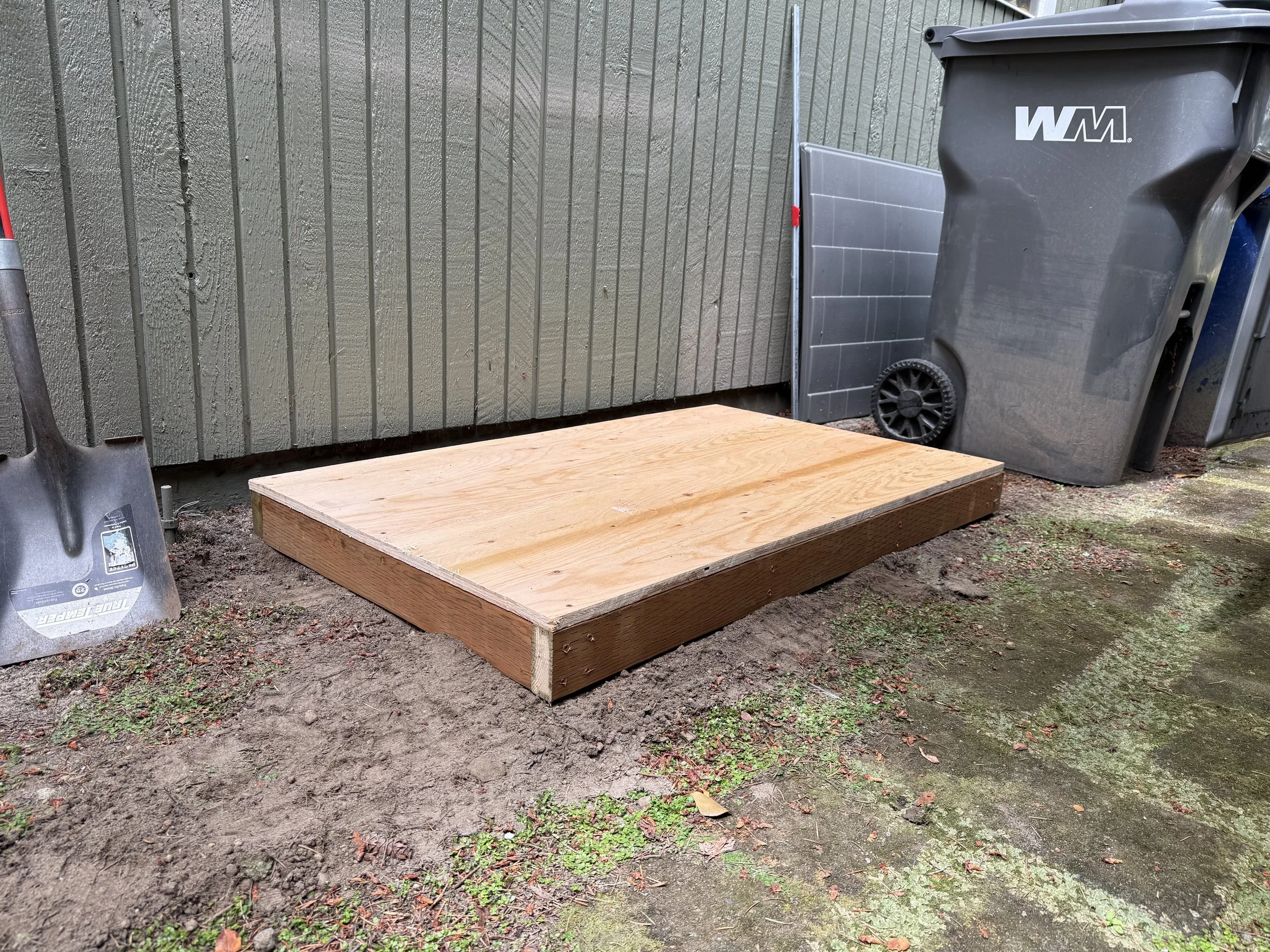 Custom-built wood platform designed to provide a level, sturdy base for an existing generator enclosure. 