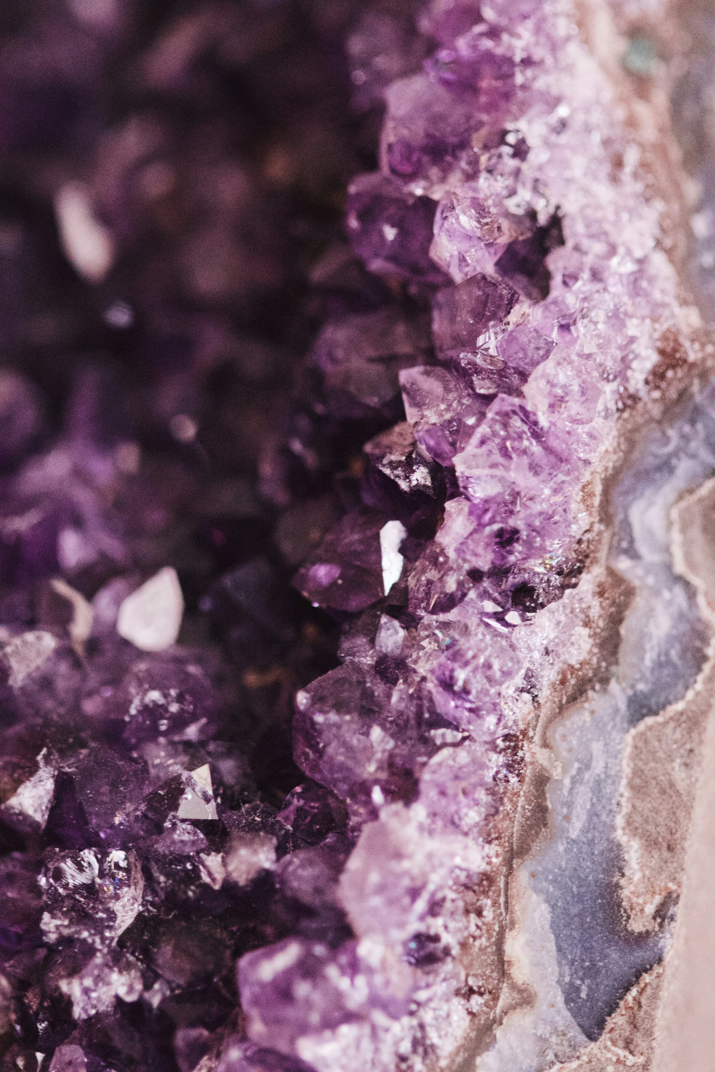 Close-up of purple and violet crystalline rocks or minerals with sparkles and rough texture.