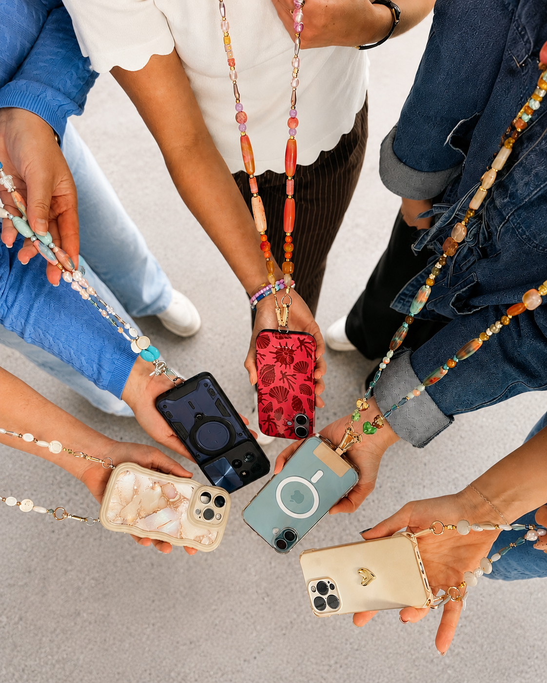 Group of people showing their decorated phones with beaded lanyards in a circle.