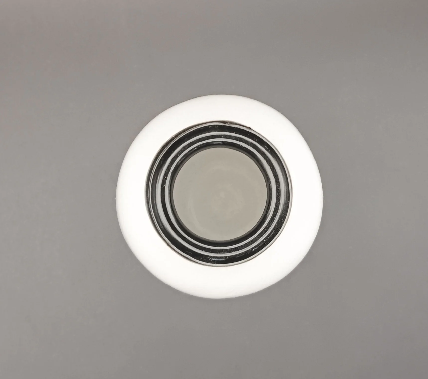 A close-up of a white skate bearing on a gray surface.