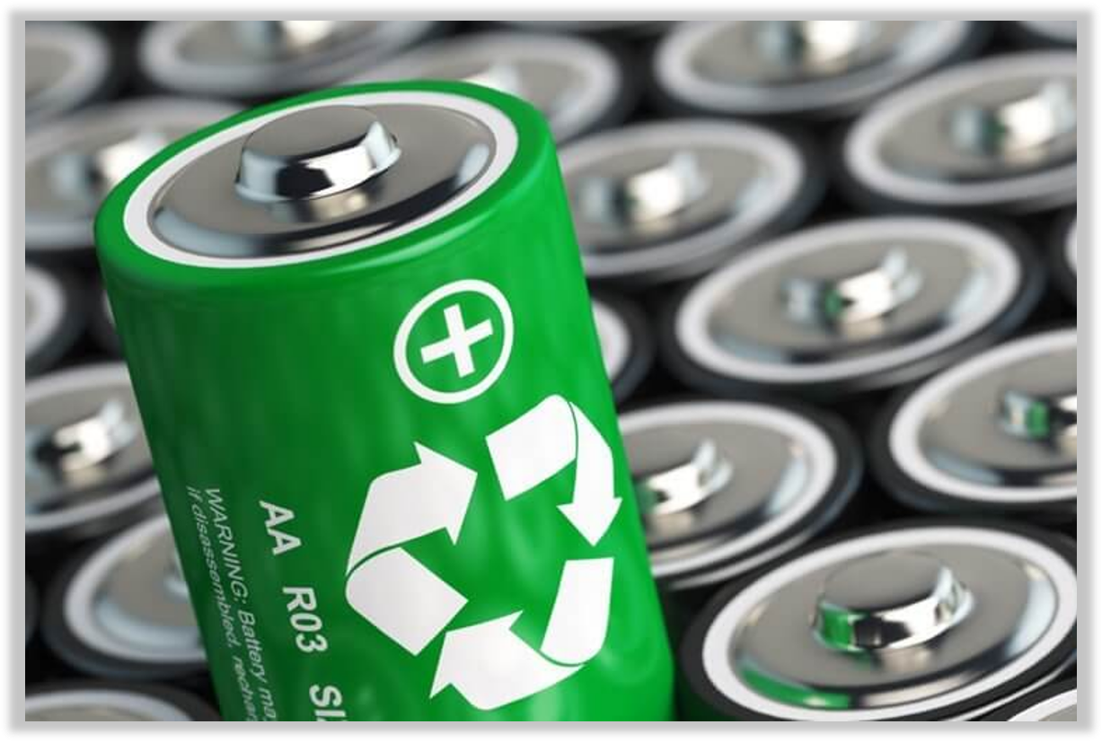 A green AA rechargeable battery with recycling symbols and warning text, lying in front of a pile of similar batteries.