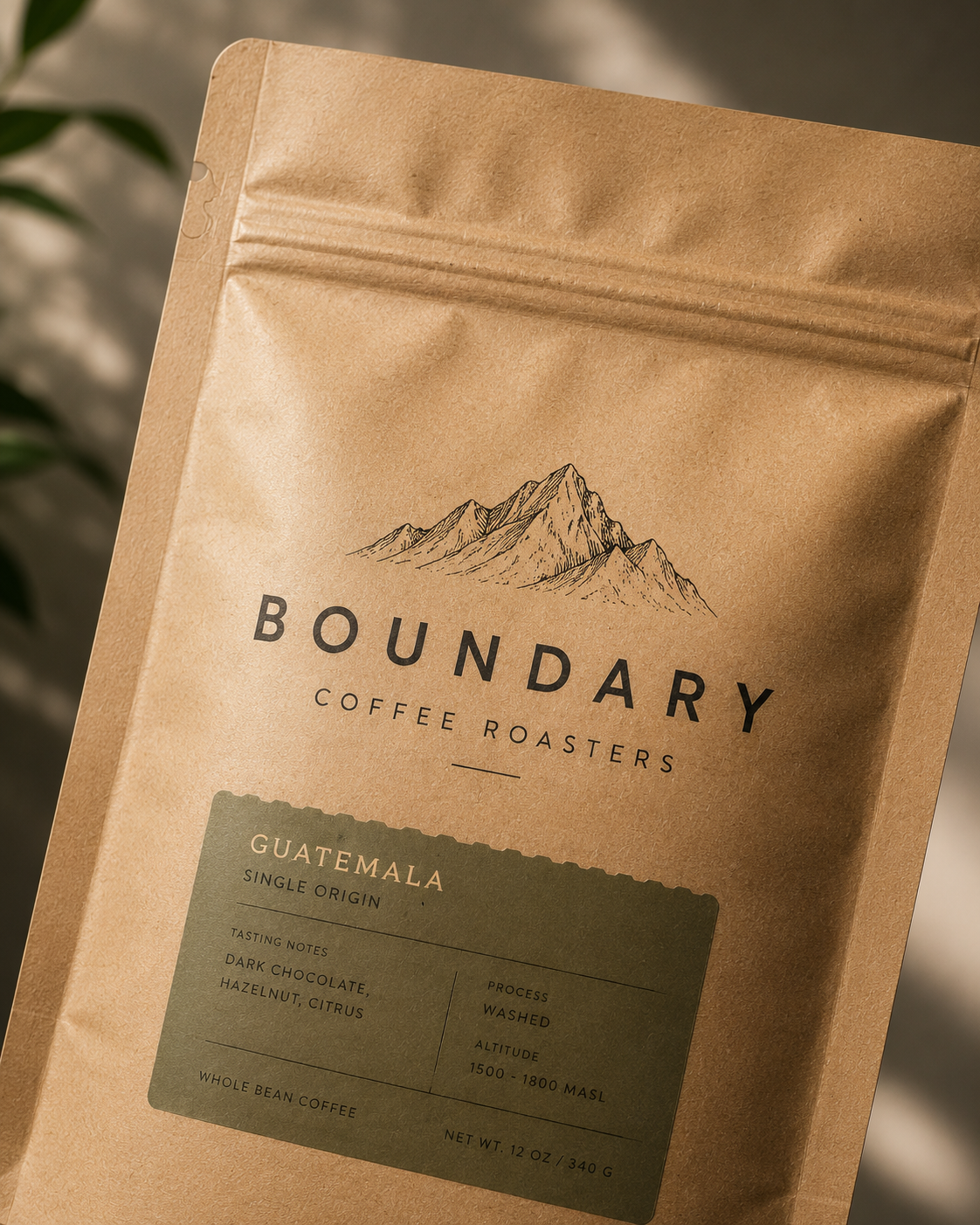 Close-up of a coffee bag from Boundary Coffee Roasters, featuring a mountain illustration and label indicating Guatemala single origin beans, with notes of dark chocolate, hazelnut, citrus, and processed via washed method at 1500-1800 meters altitude.